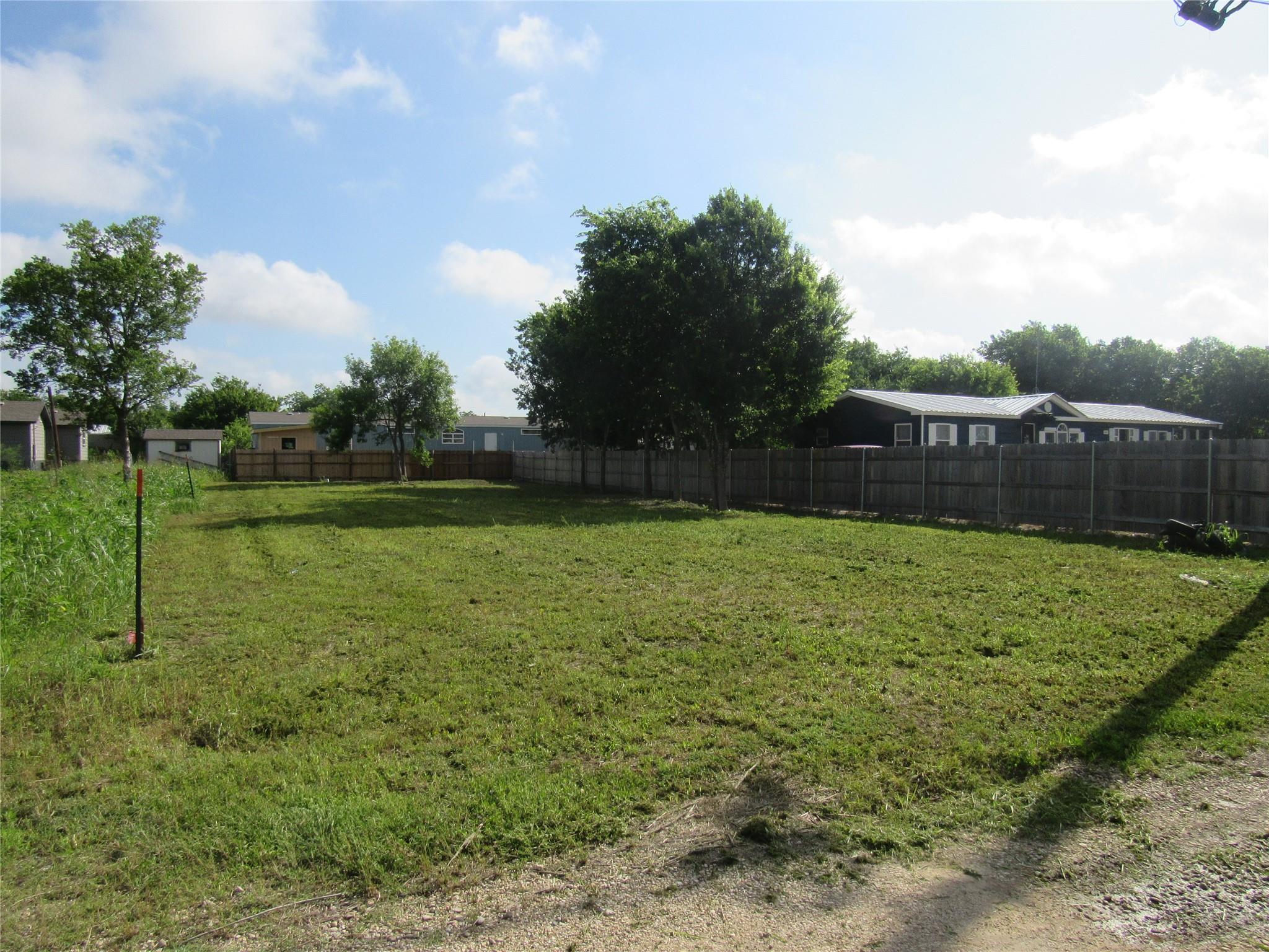 A generous, cleared lot awaits development, borde