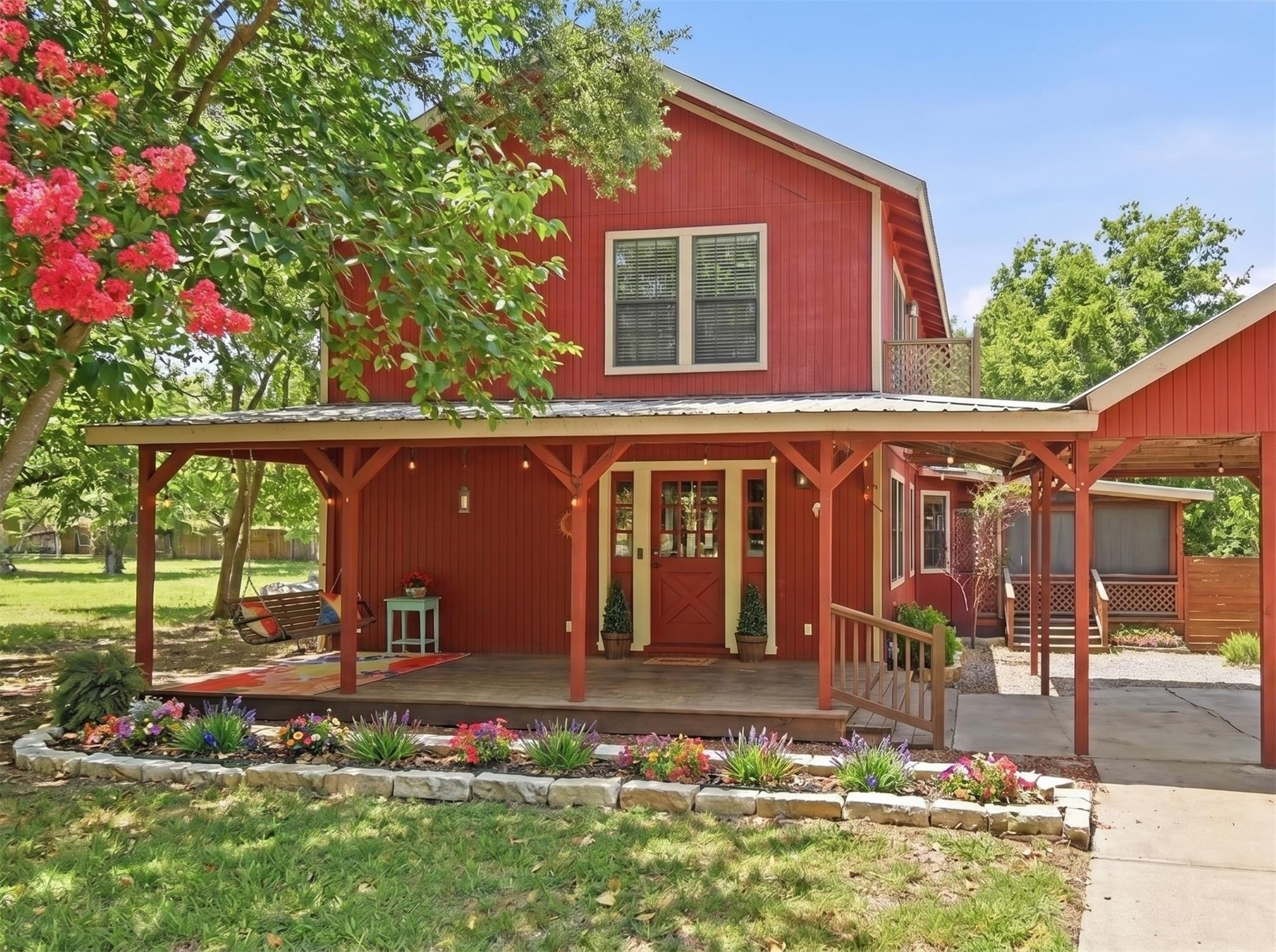 A charming red country home presents a welcoming 