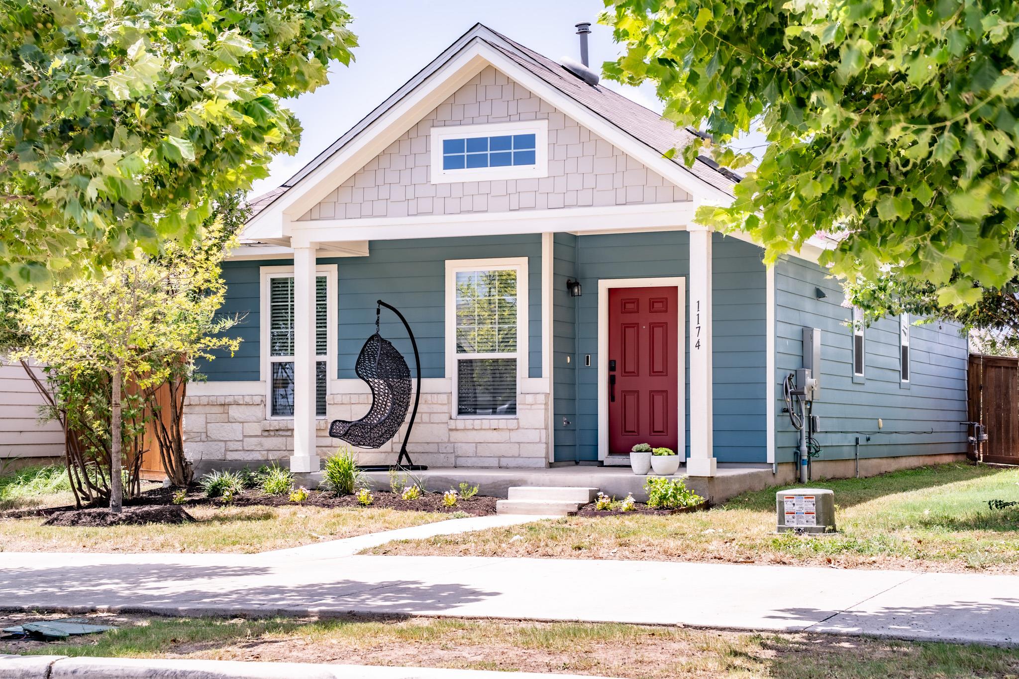 A charming home welcomes with a vibrant red door 