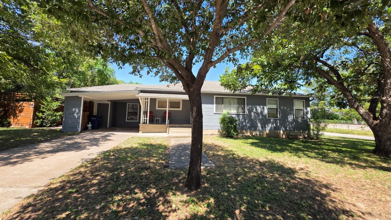 Mature trees shade the front yard and a welcoming