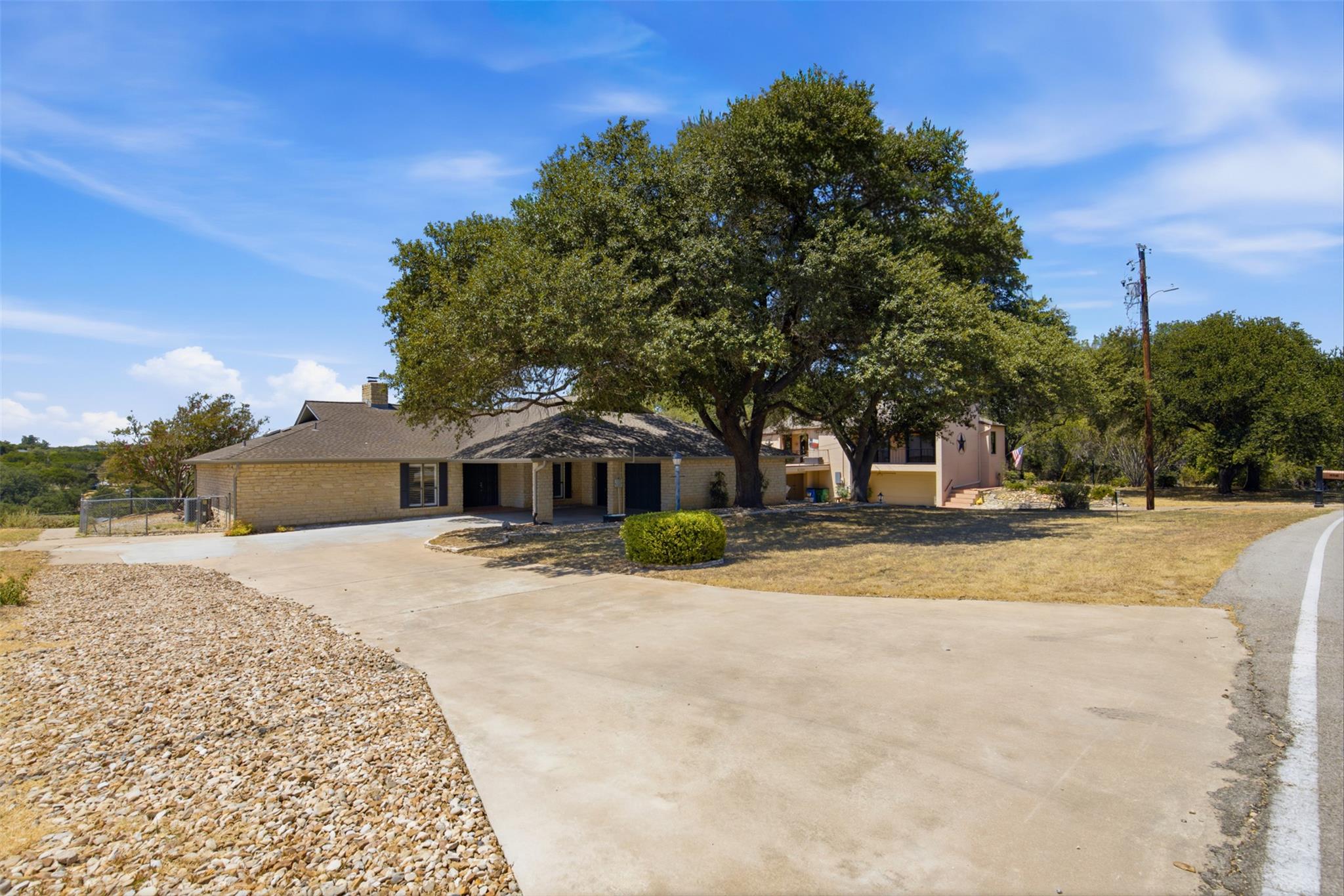 Mature shade trees frame a classic stone exterior