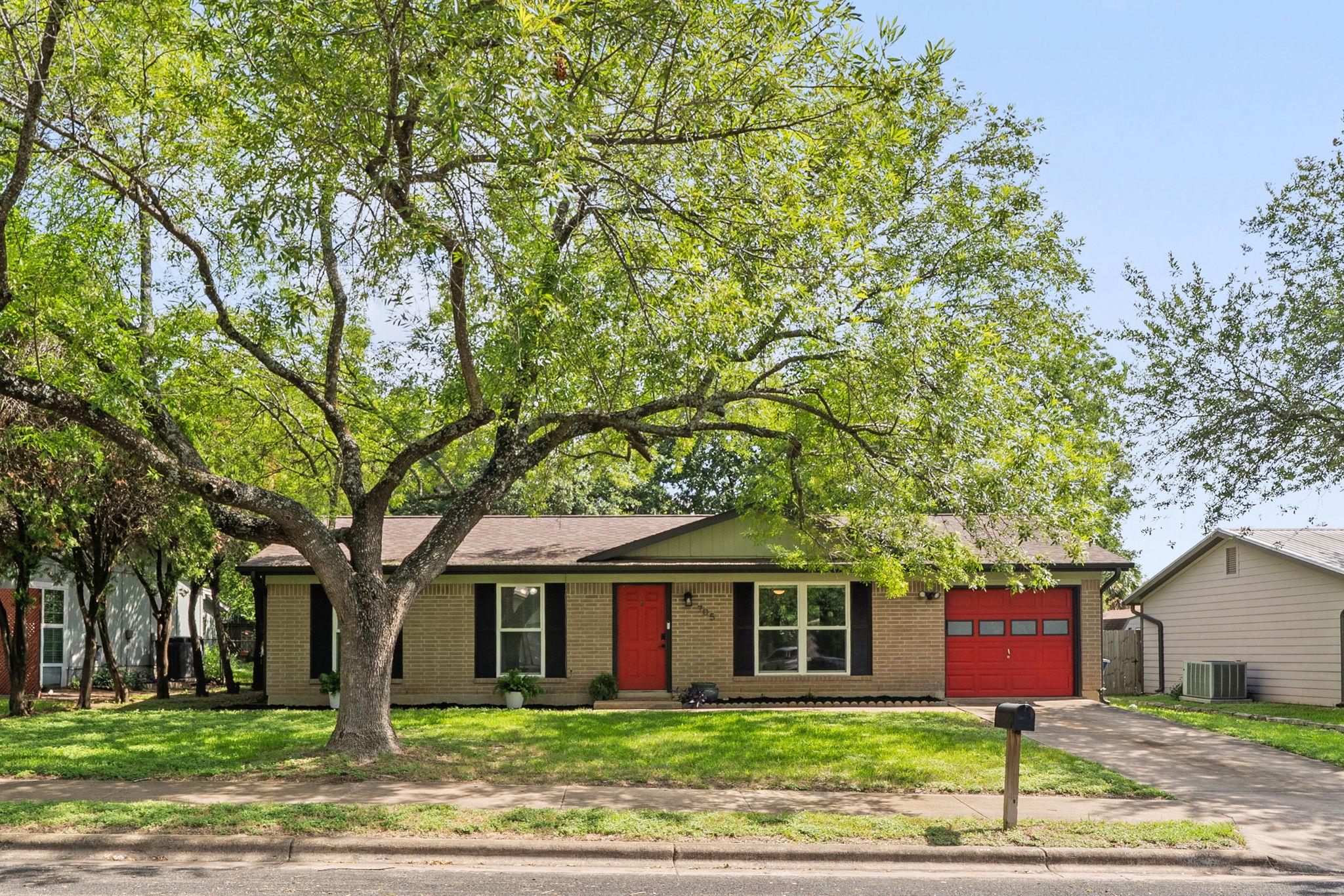 Brick facade with a vibrant red entry door create