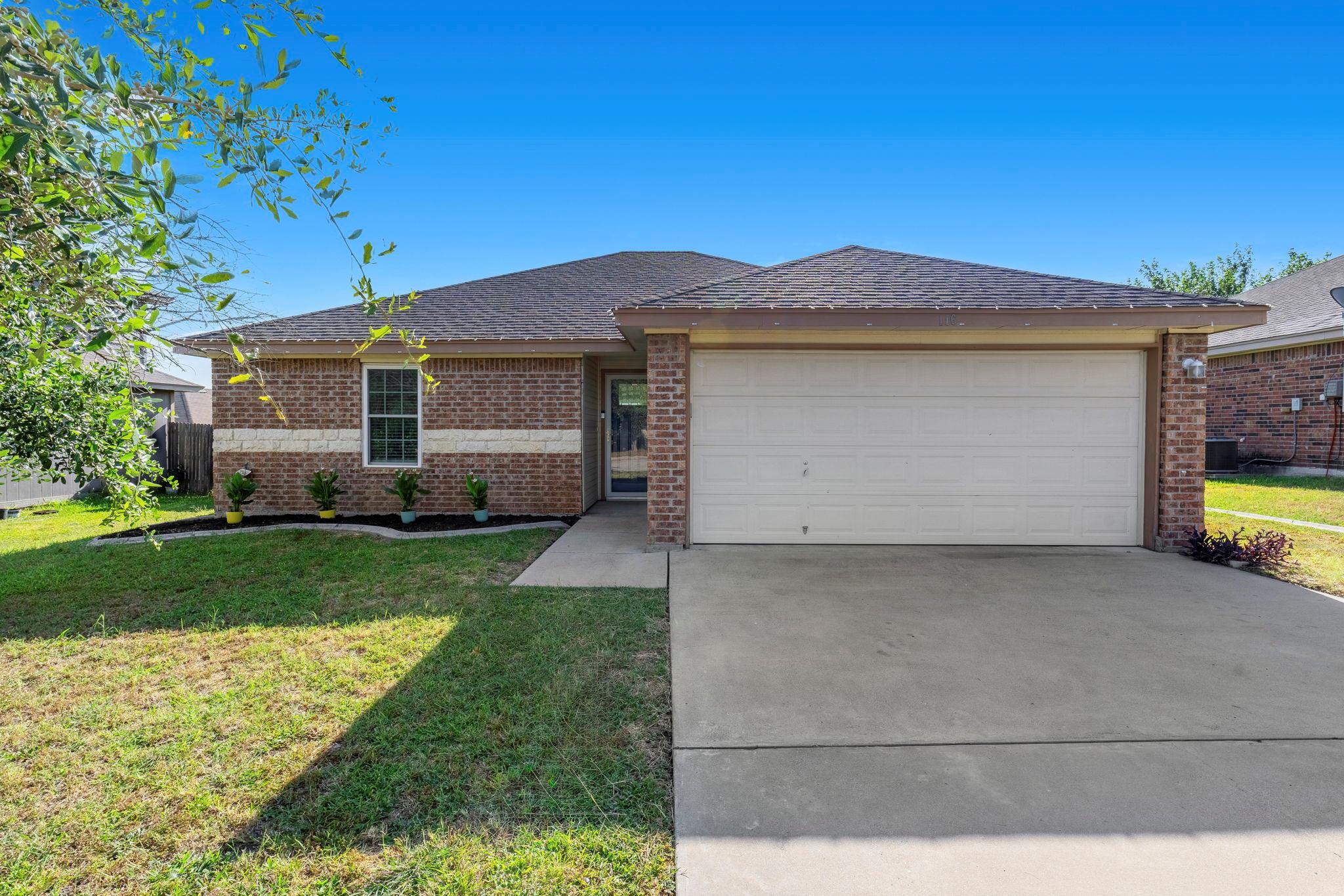 A classic brick exterior with a welcoming lawn an