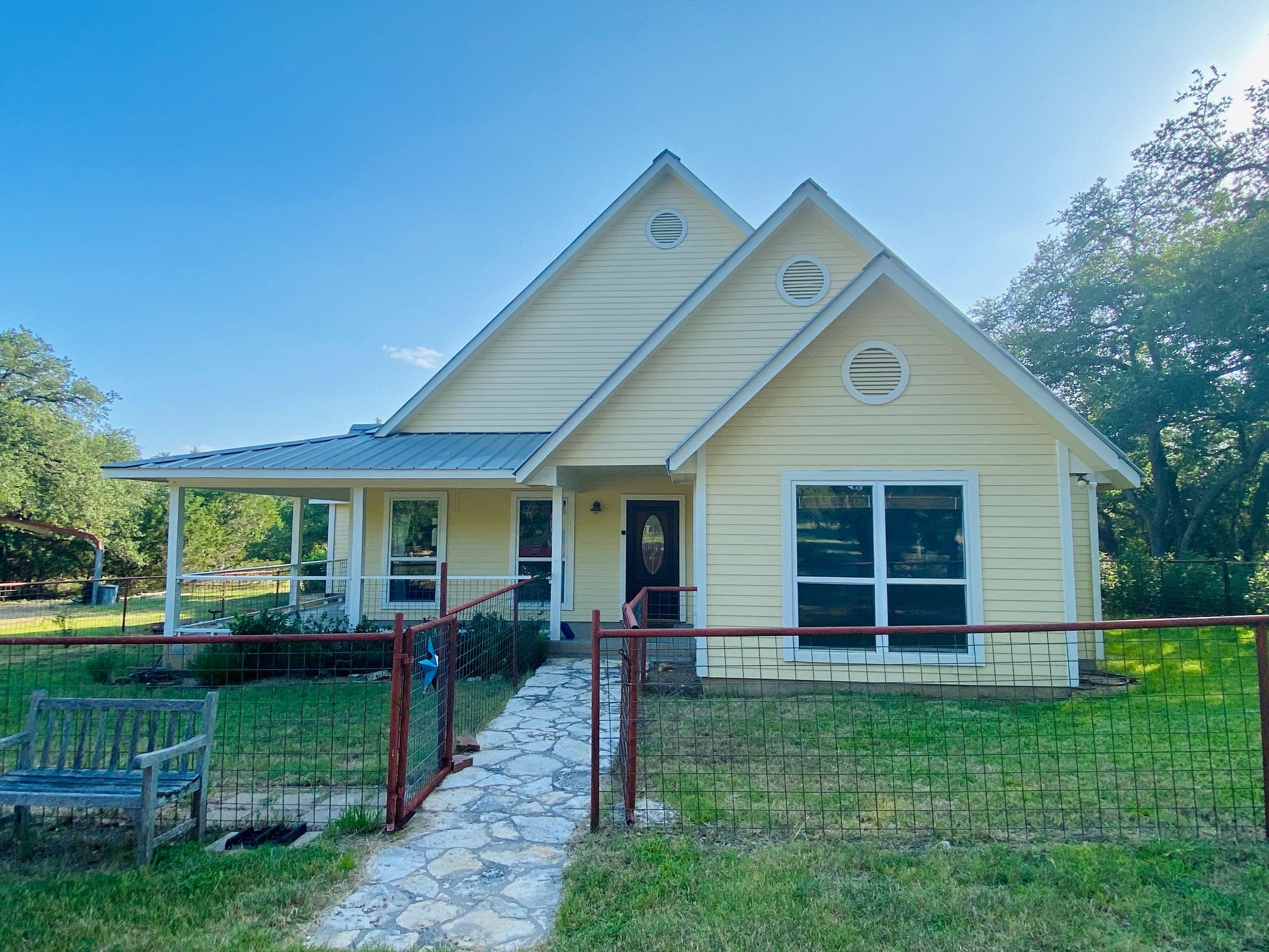 A charming yellow home features a covered porch a