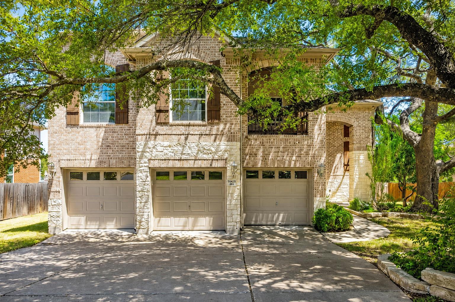 Mature shade trees frame a handsome brick and sto