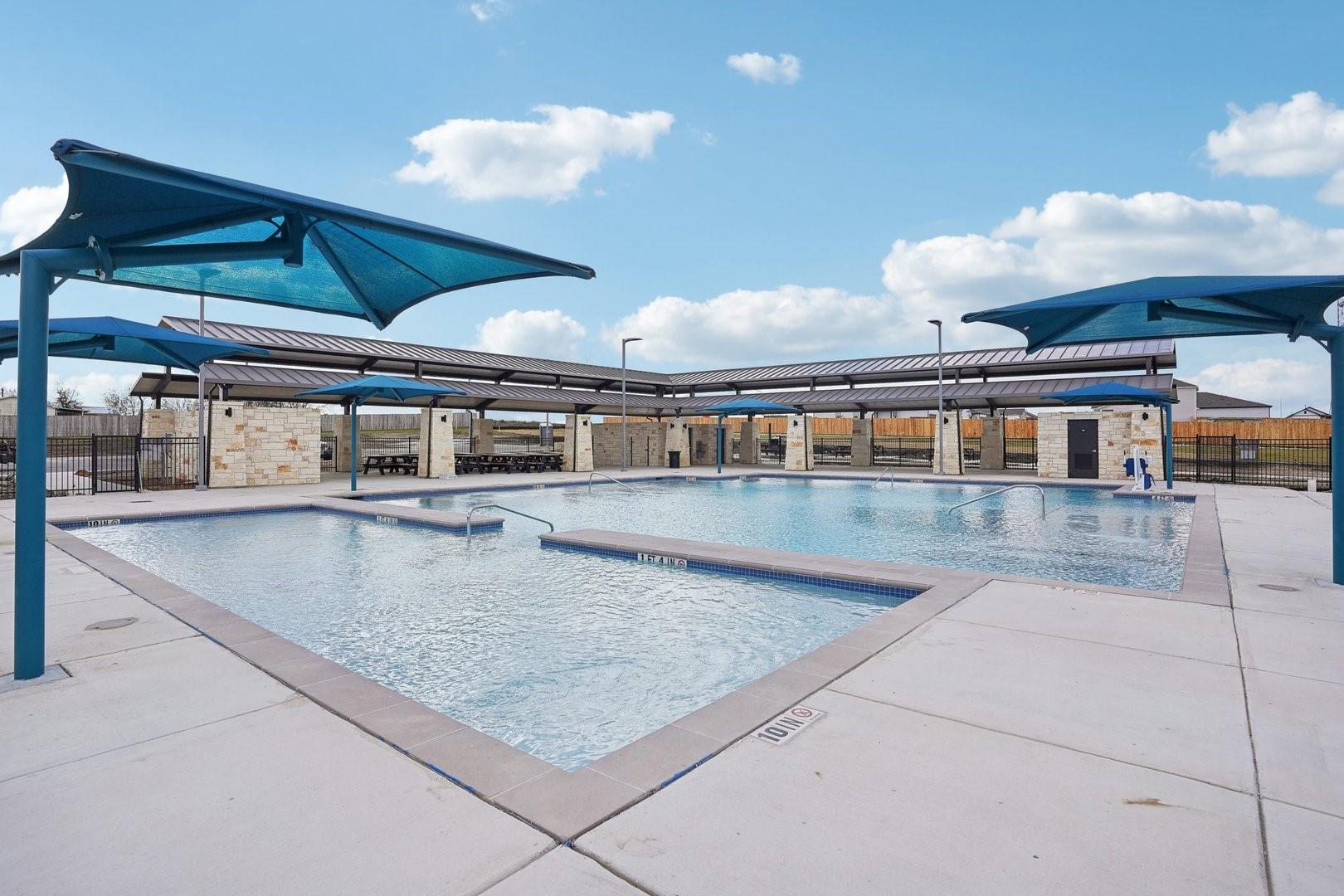 A refreshing community pool with covered seating 