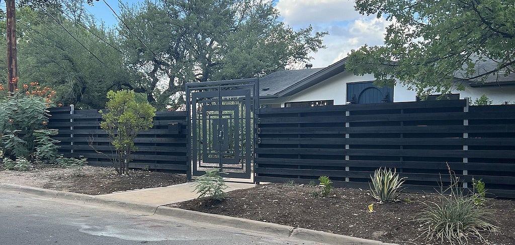 A striking modern fence with an artistic gate pro