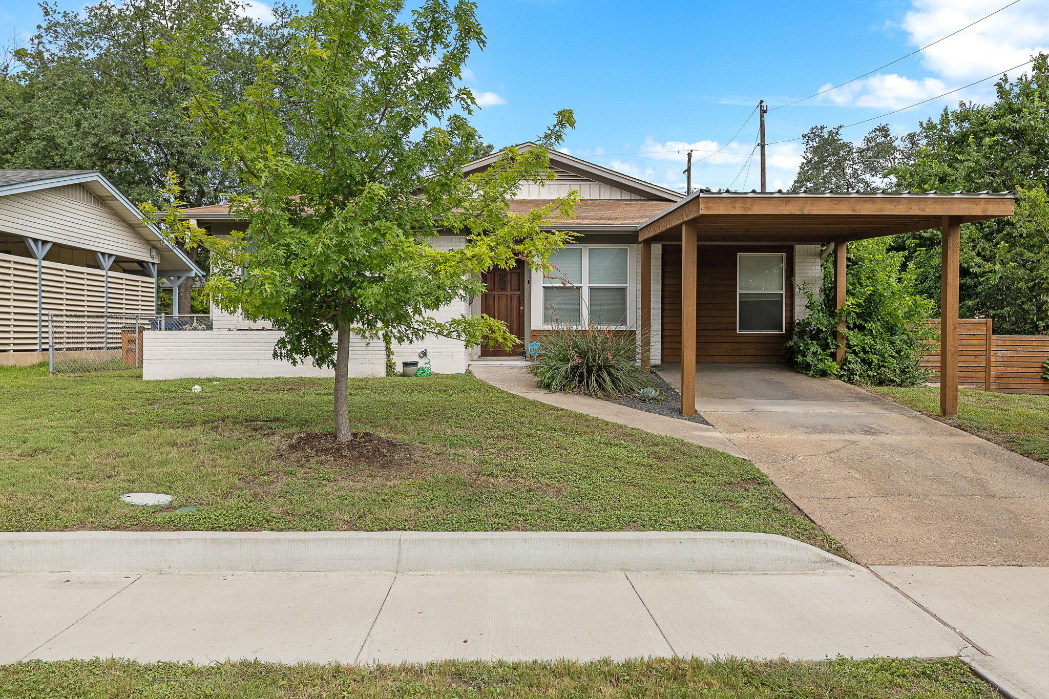 A welcoming facade with a convenient carport and 