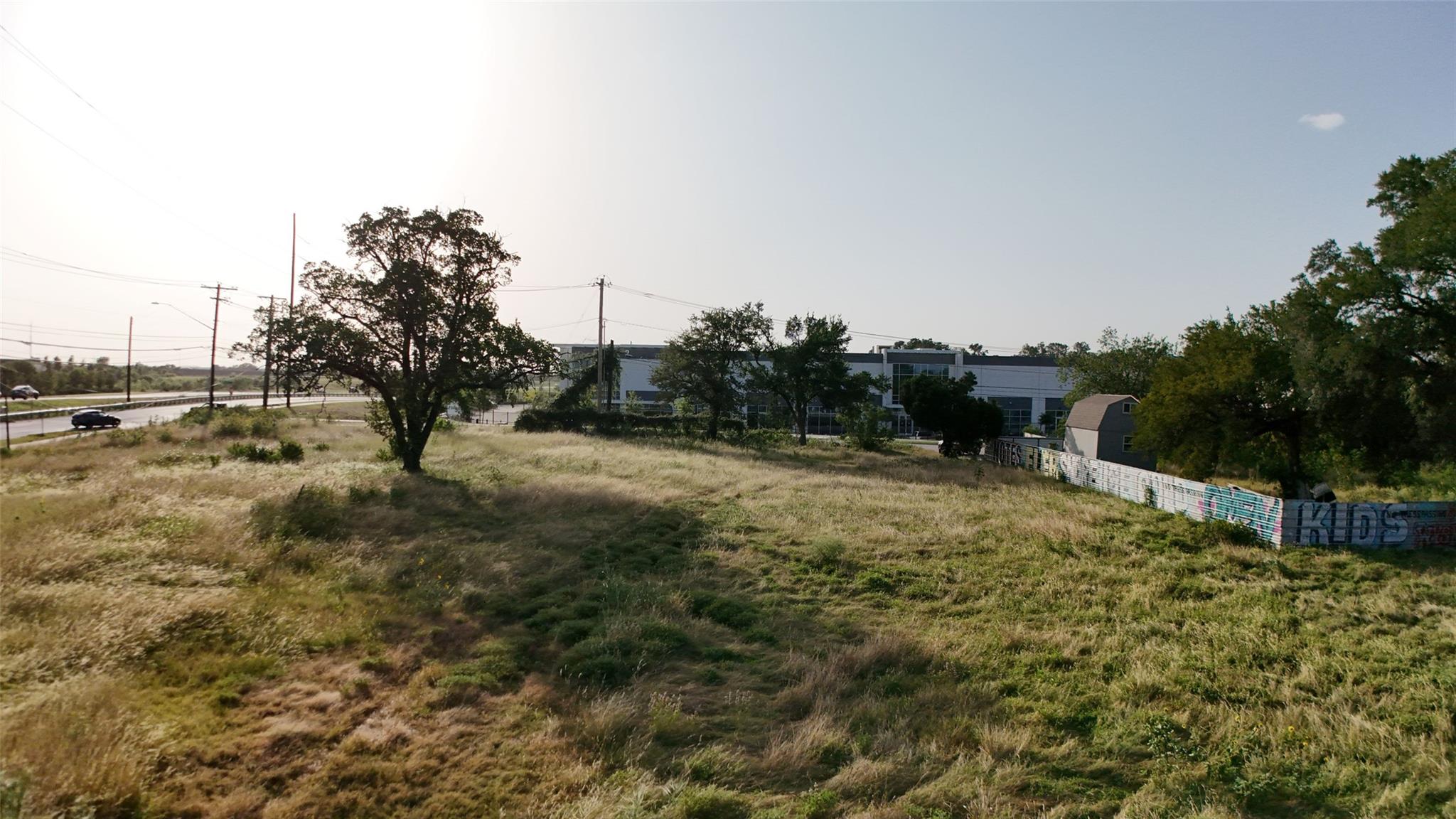 A spacious, undeveloped lot with verdant grass, o