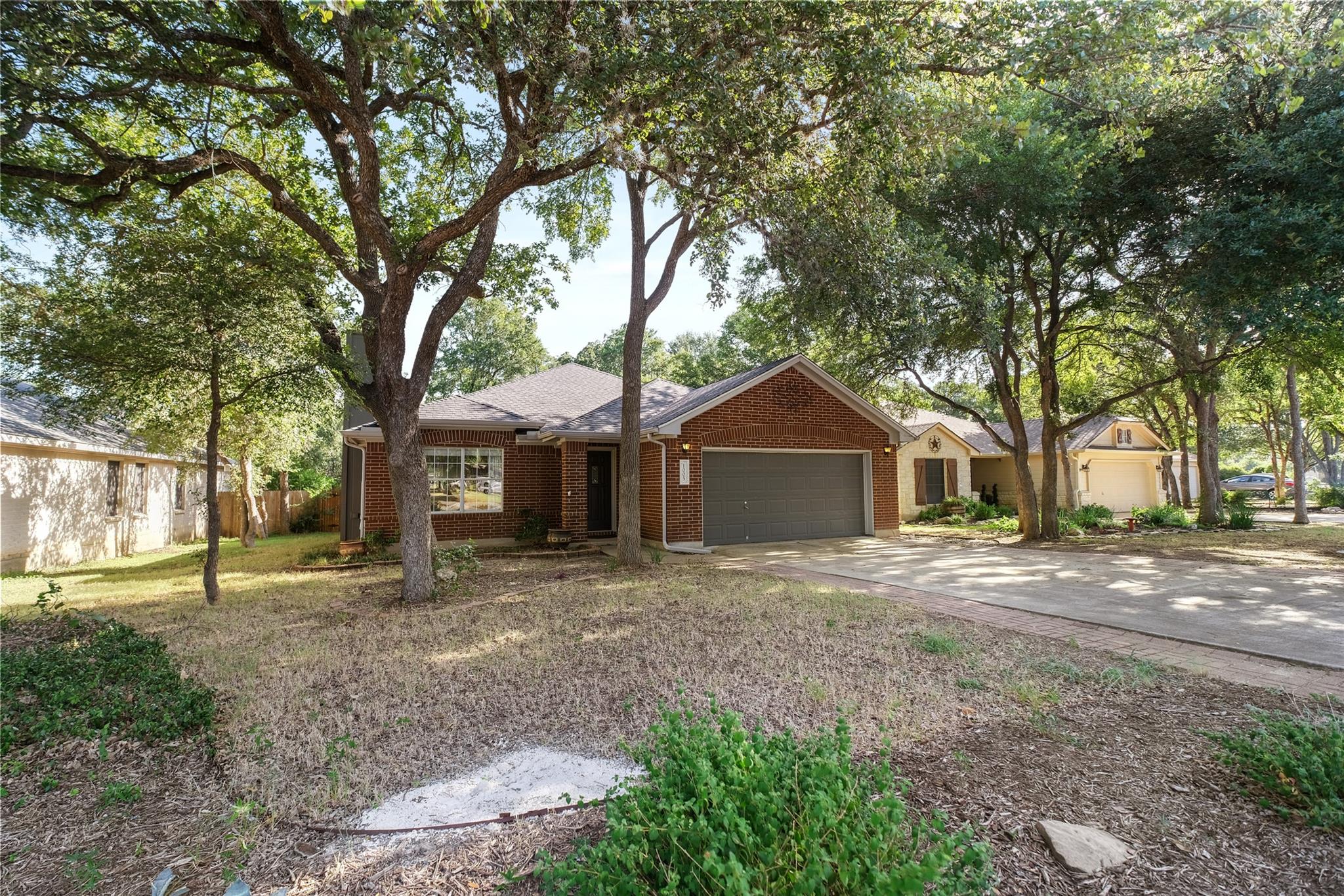 Mature trees shade this brick facade, offering a 