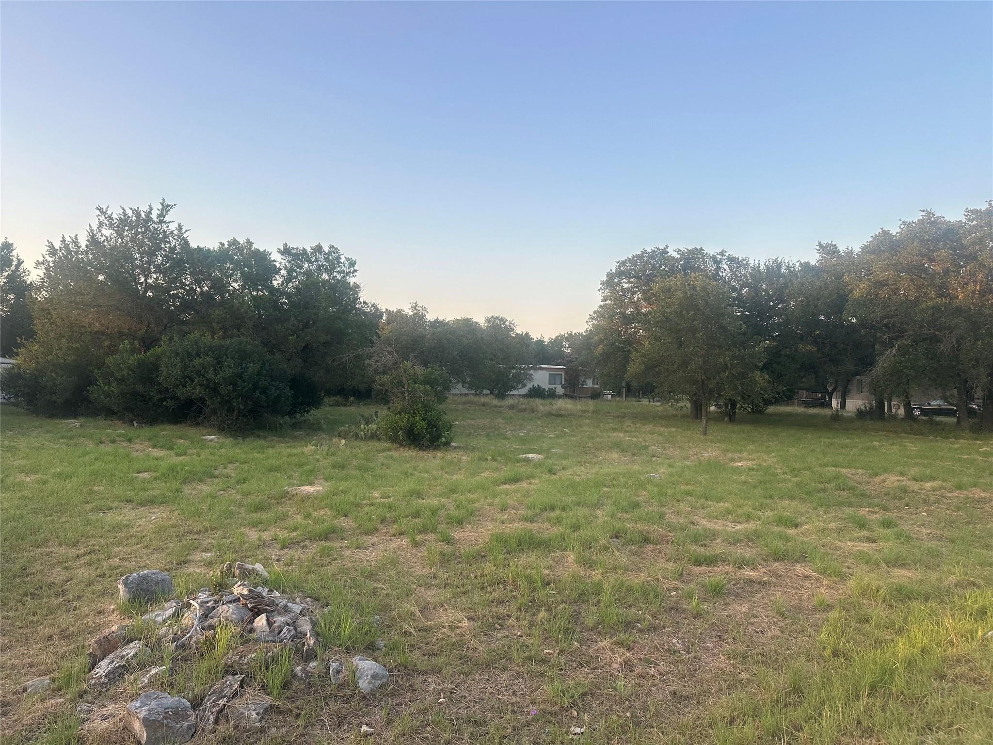 A spacious, verdant lot awaits your vision, surro
