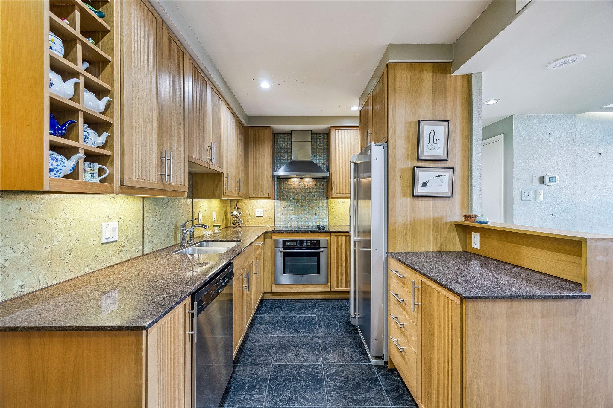 A galley kitchen with natural wood cabinetry and 