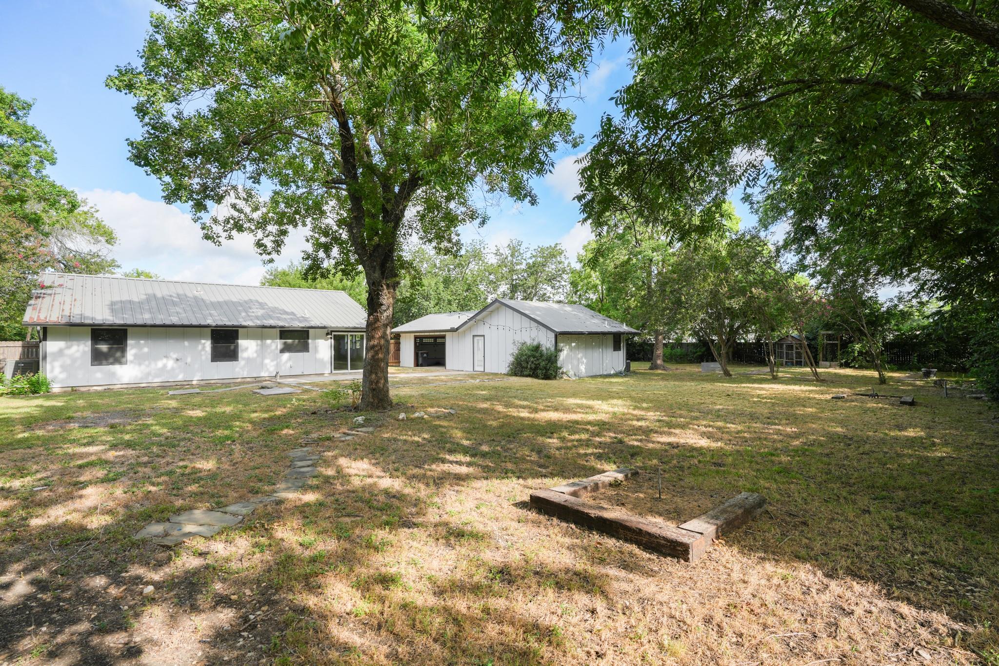 A spacious backyard with mature trees, offering a