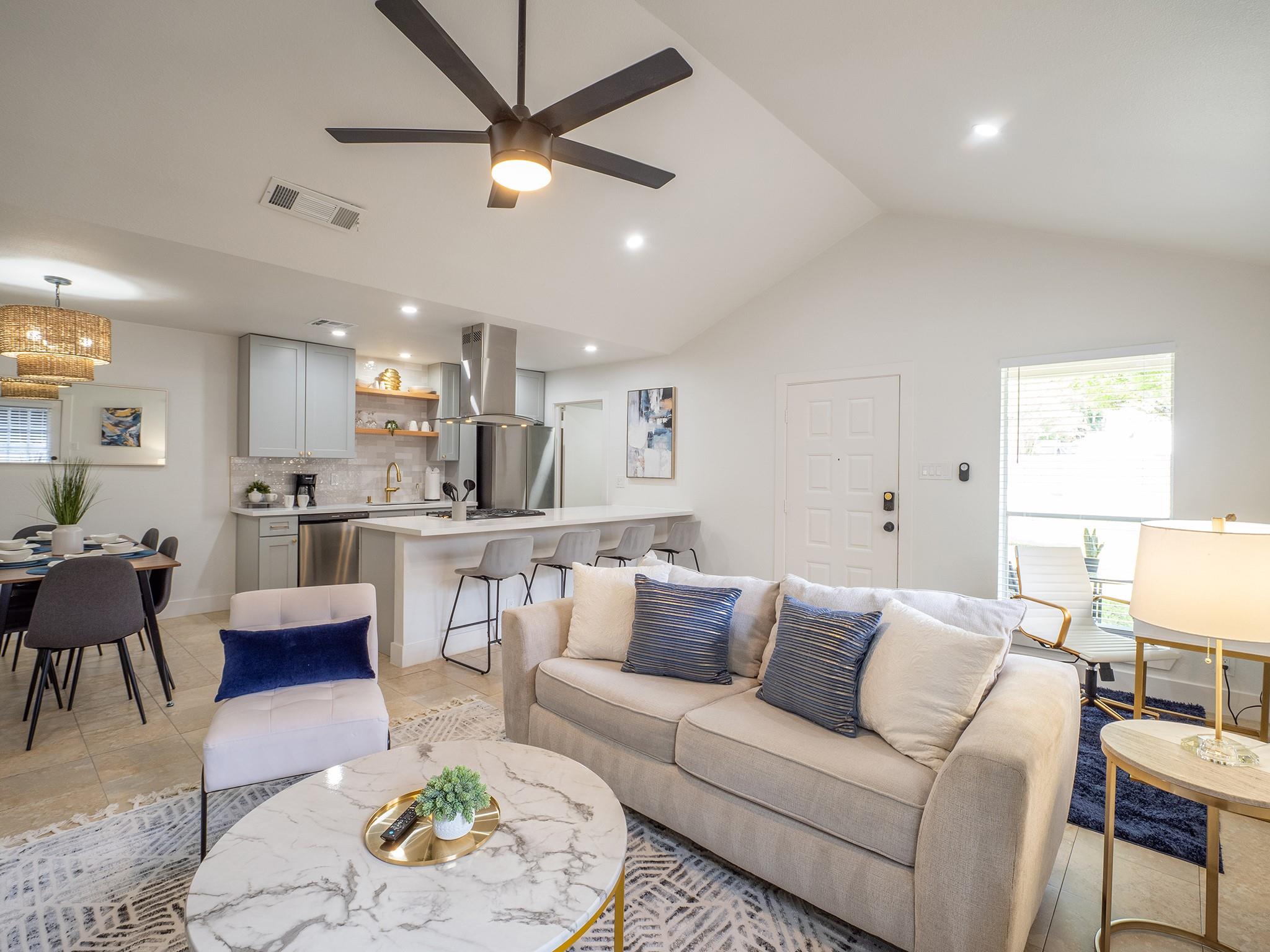An open-concept living area boasts vaulted ceilin