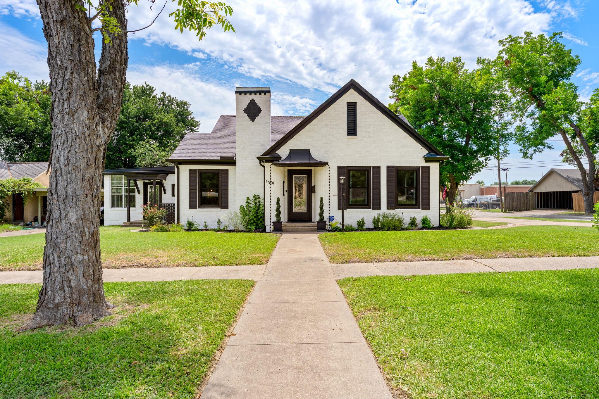 A charming facade boasts dark shutters and a dist