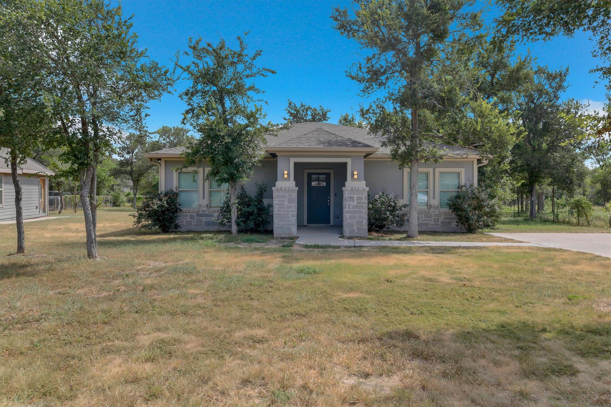 A welcoming front porch, shaded by mature trees, 