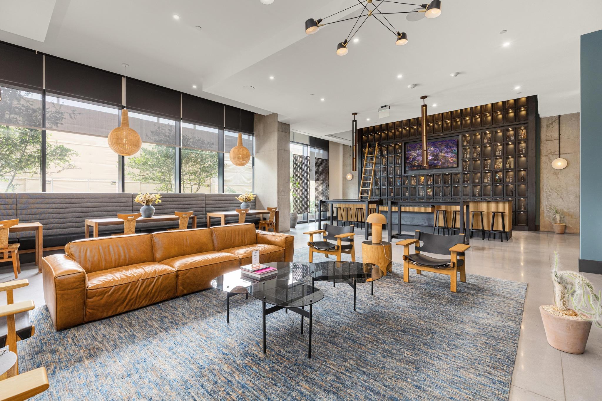 A vibrant common area features a long leather sof
