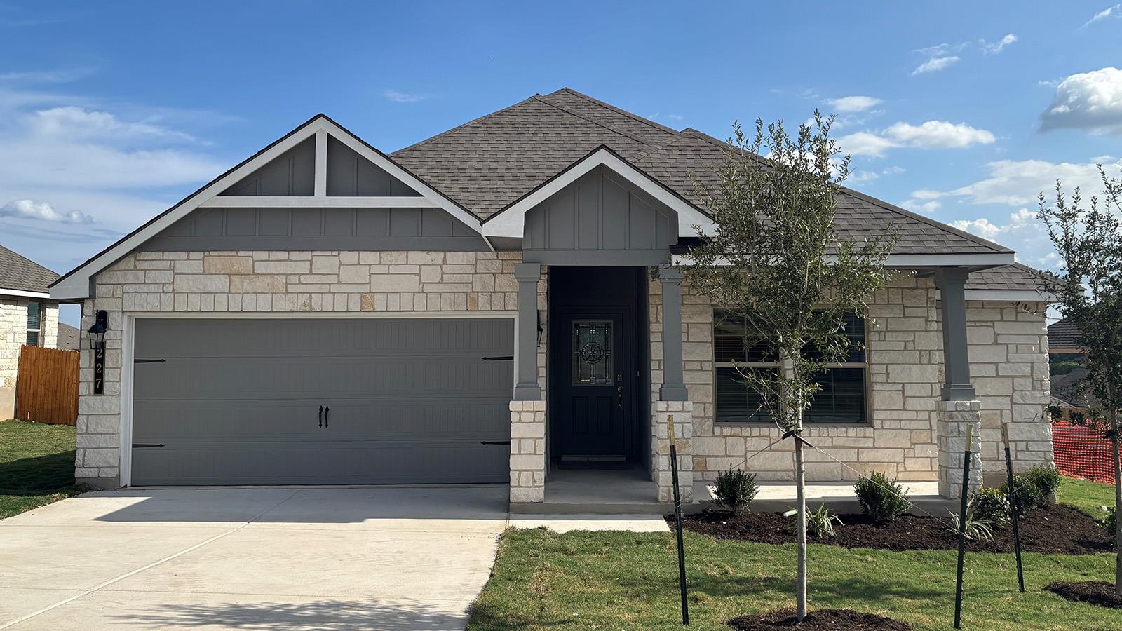 An inviting stone facade meets a spacious two-car