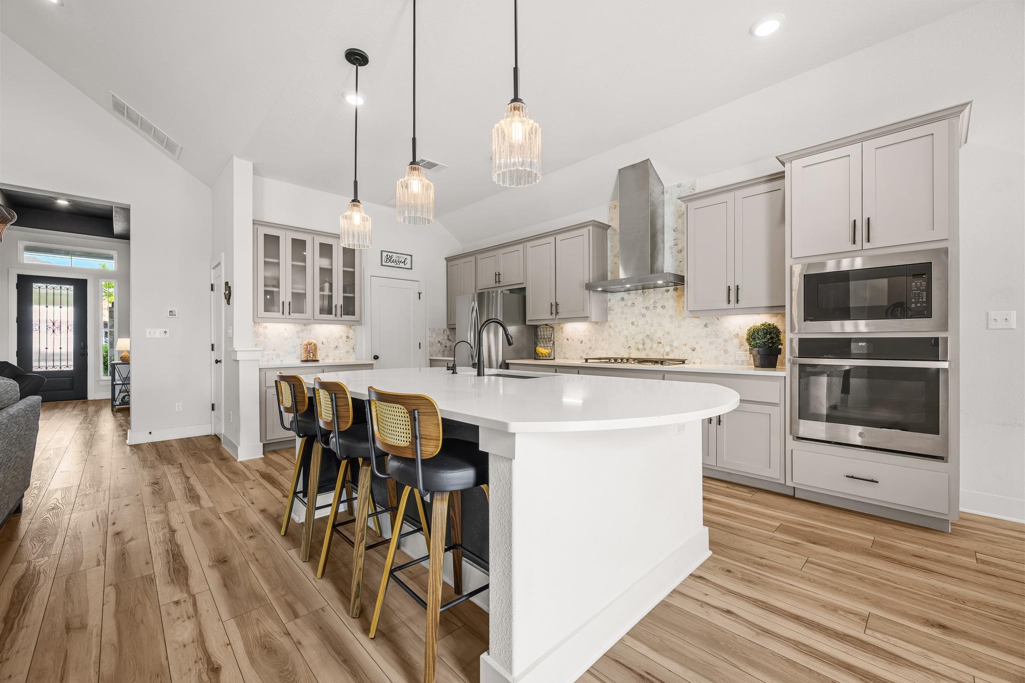 A pristine kitchen features a large island and am