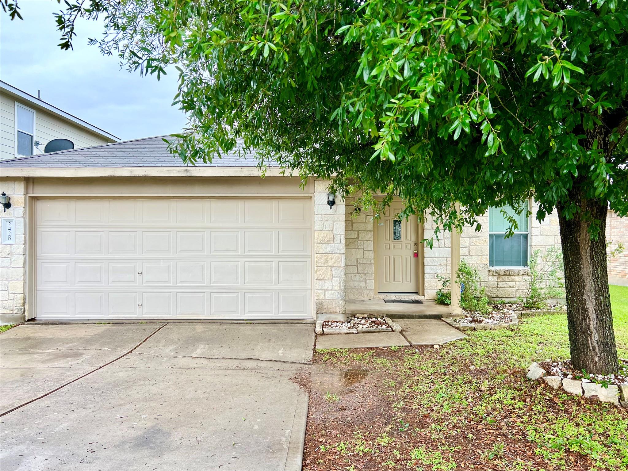 A welcoming stone facade with an attached garage 