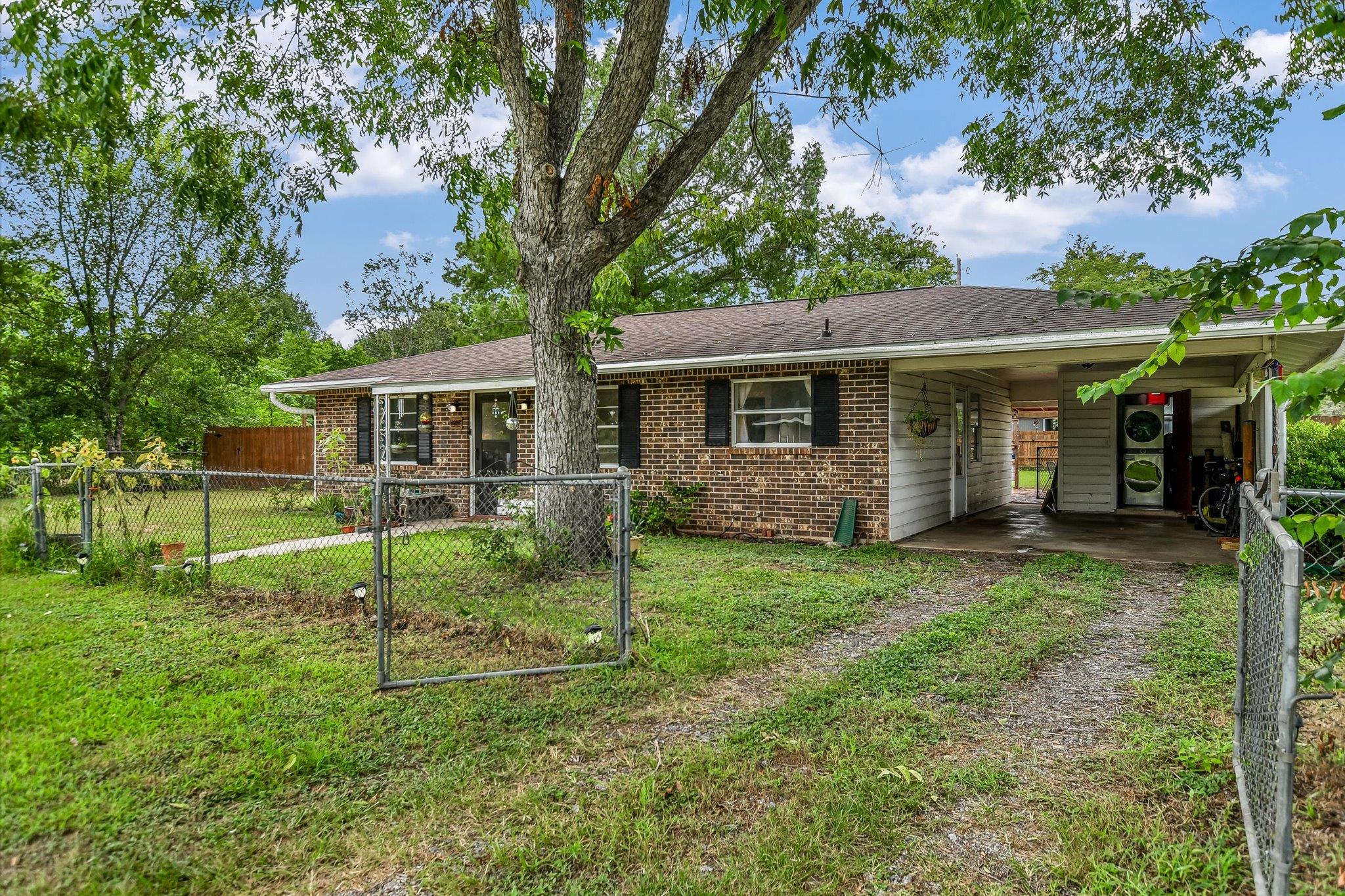 A classic brick exterior home with a carport offe