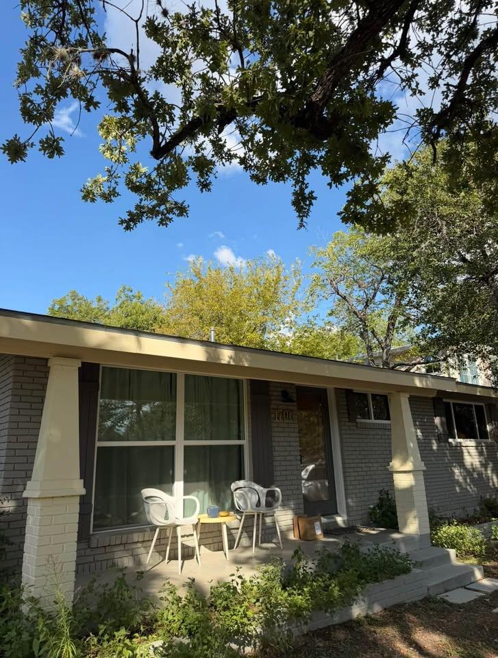 Mature trees shade a welcoming front porch framed