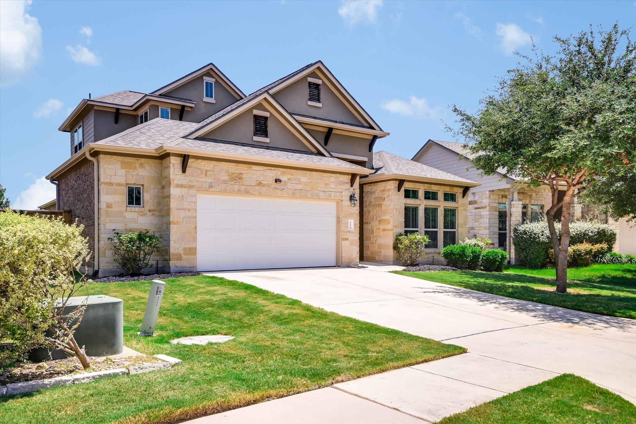 A welcoming stone and stucco home presents a spac