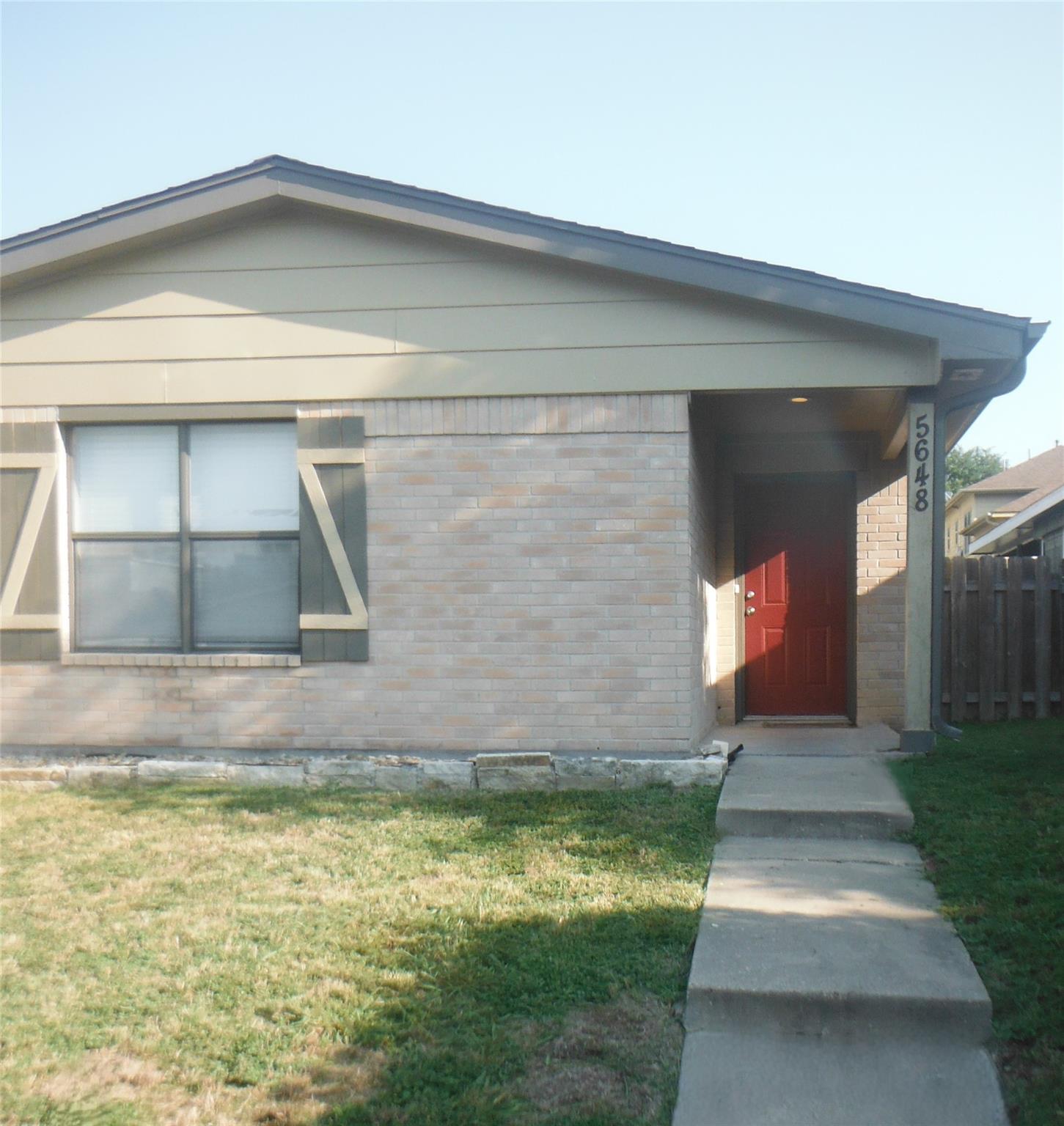 A welcoming brick facade with an inviting red doo