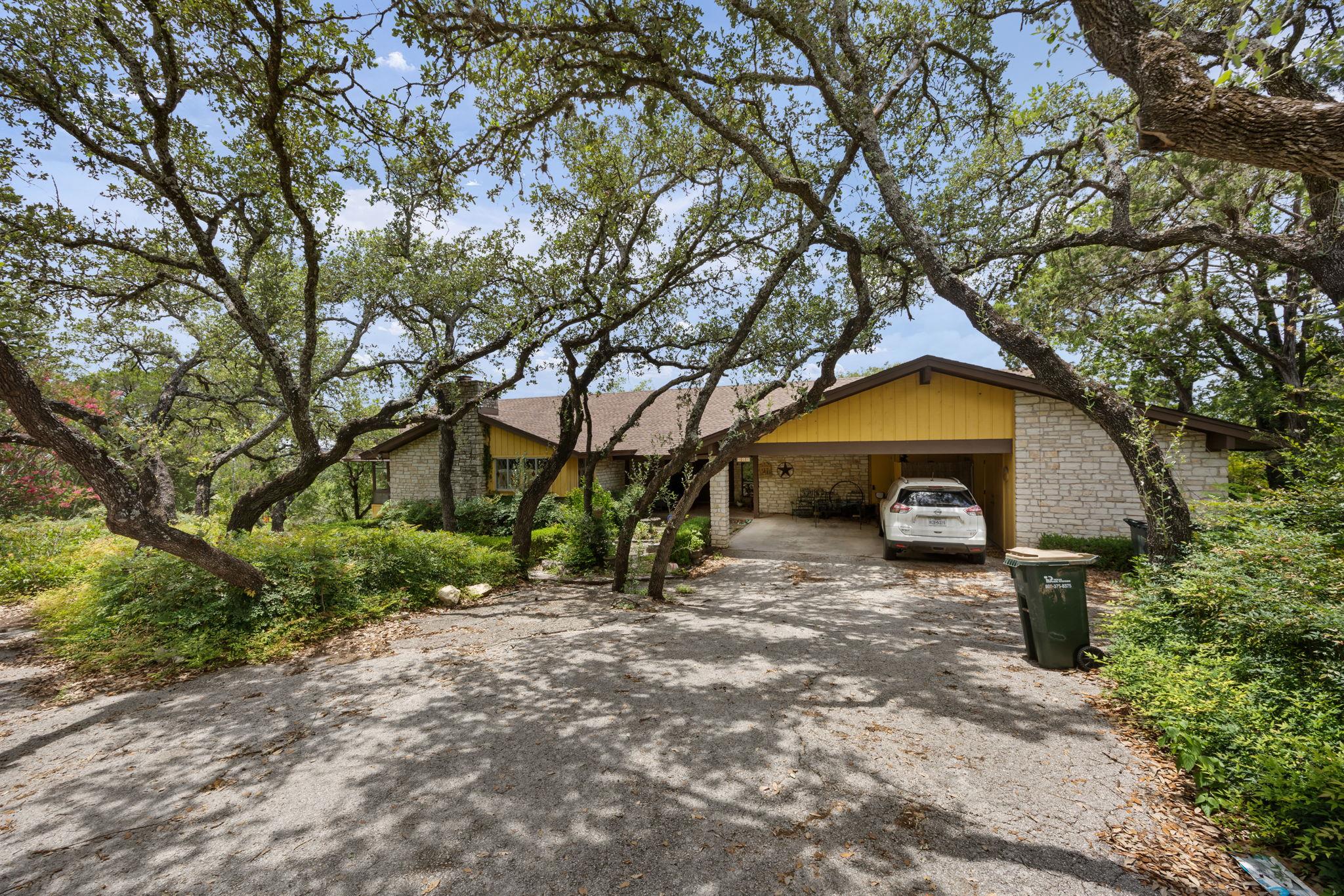Mature trees canopy this inviting residence, feat