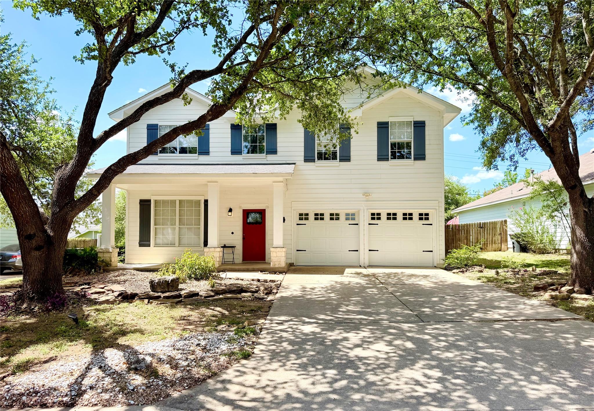 White siding and a vivid red door adorn this invi