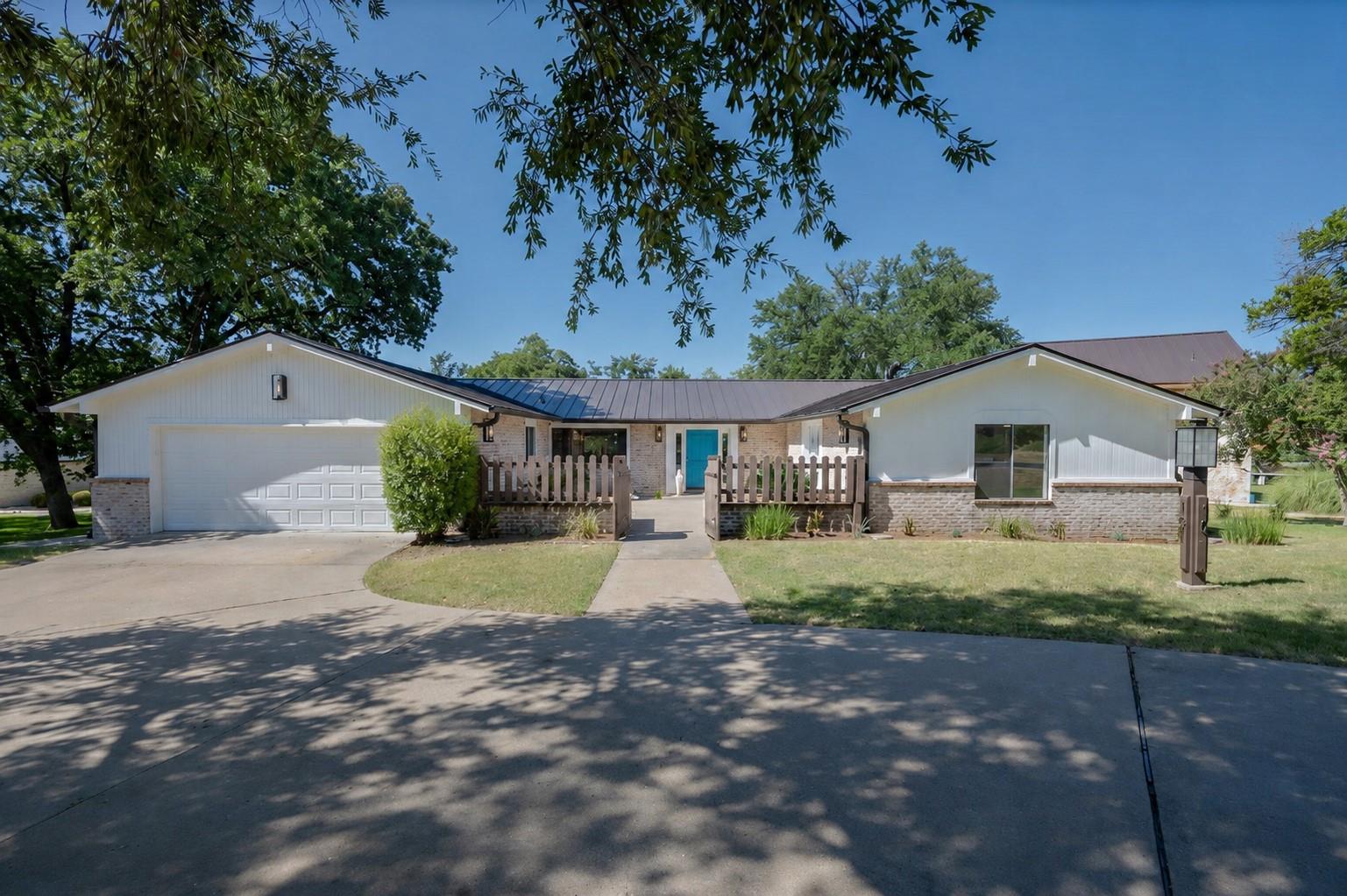 A welcoming driveway leads to a modern ranch-styl