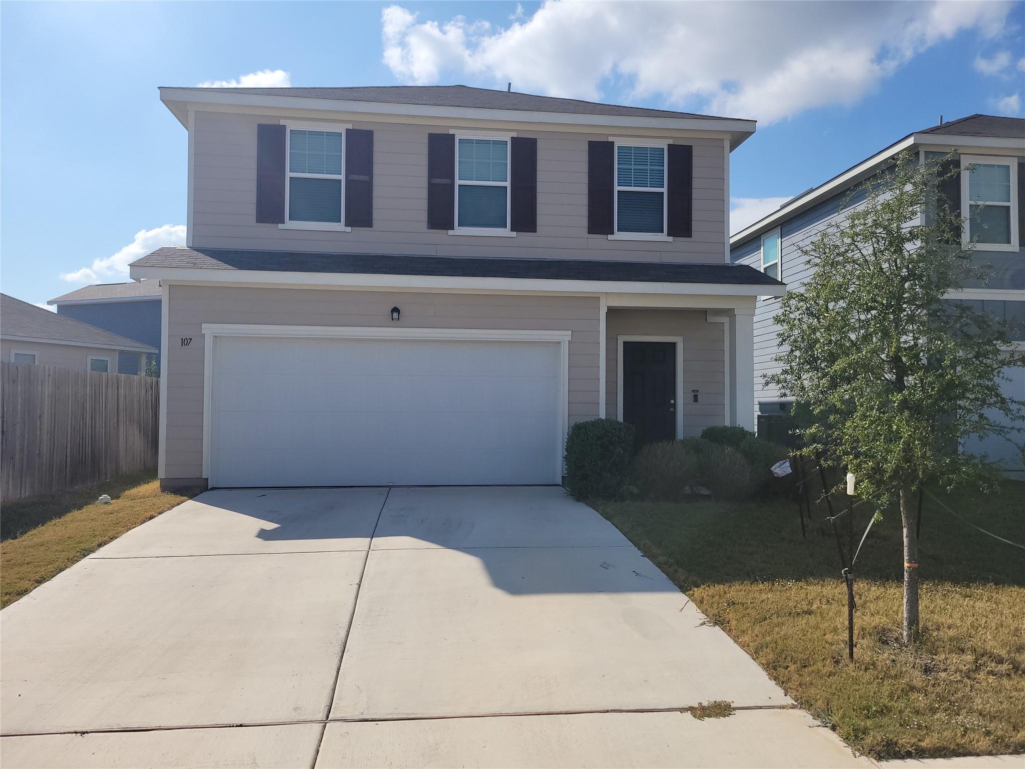 A classic two-story home with a wide driveway and