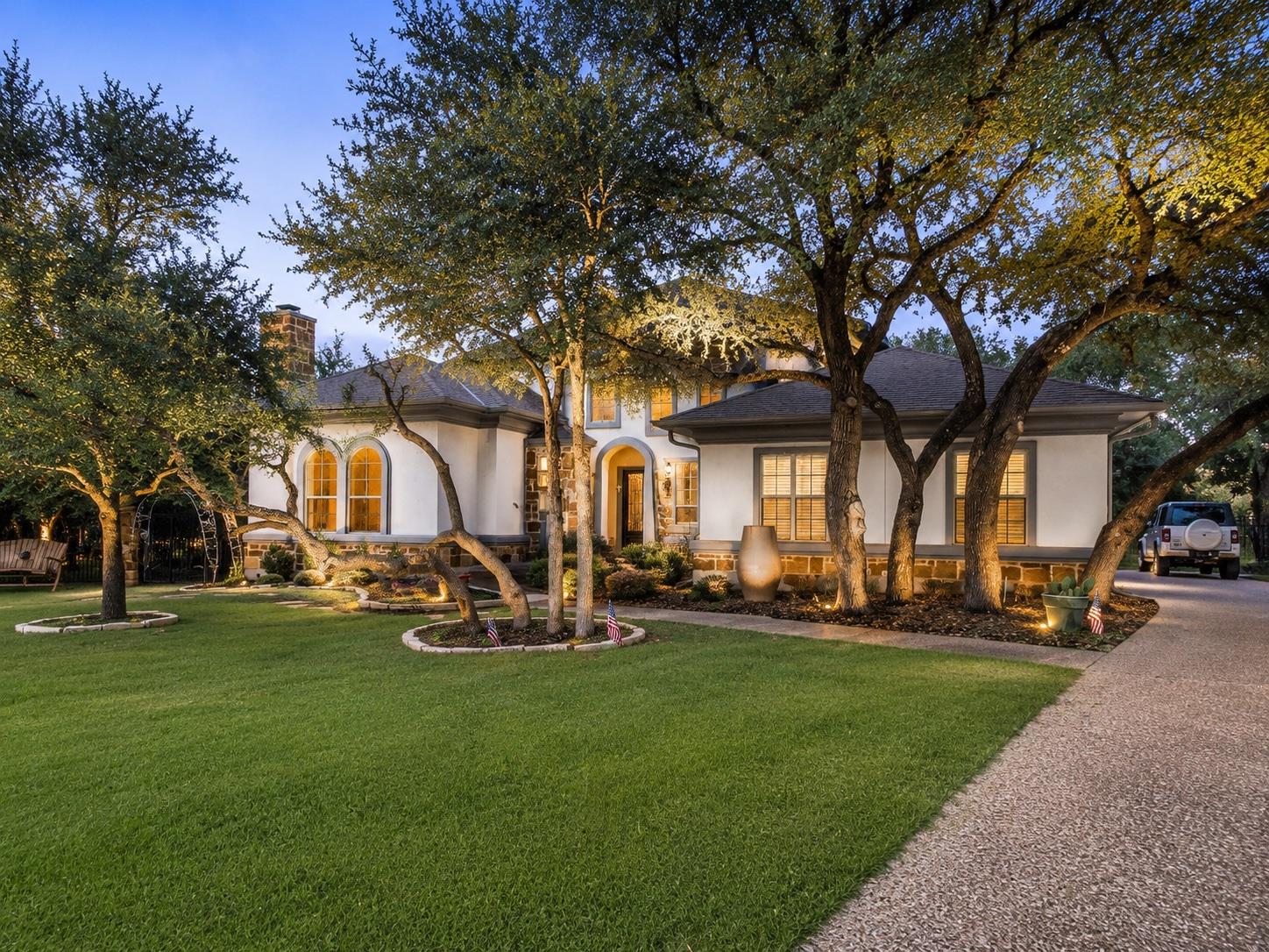 Mature trees and inviting landscape lighting high