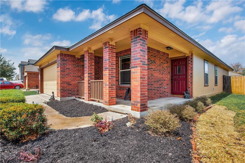 A welcoming brick exterior boasts a covered front