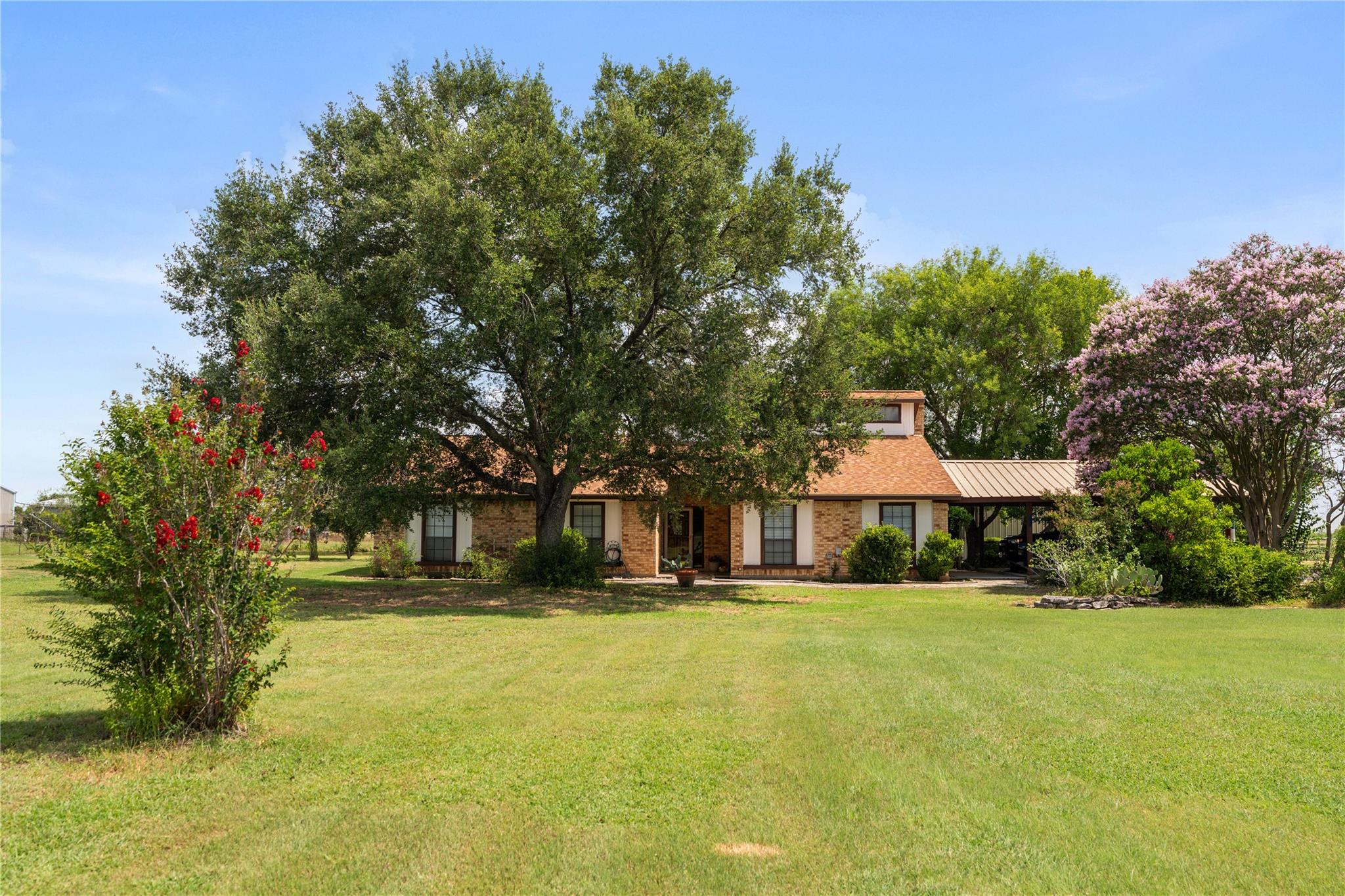 Mature trees frame this traditional brick residen