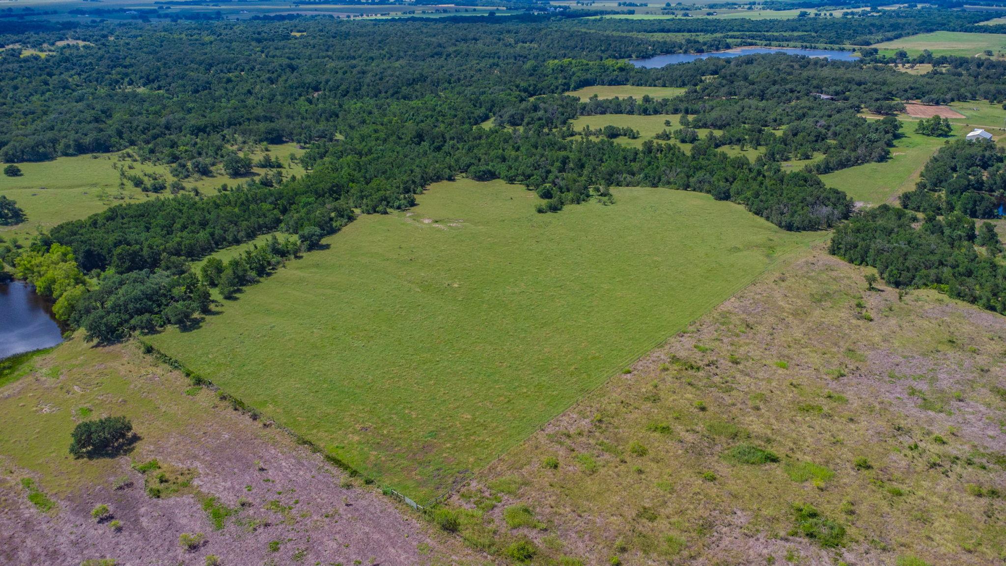 A verdant field bordered by natural waterways and