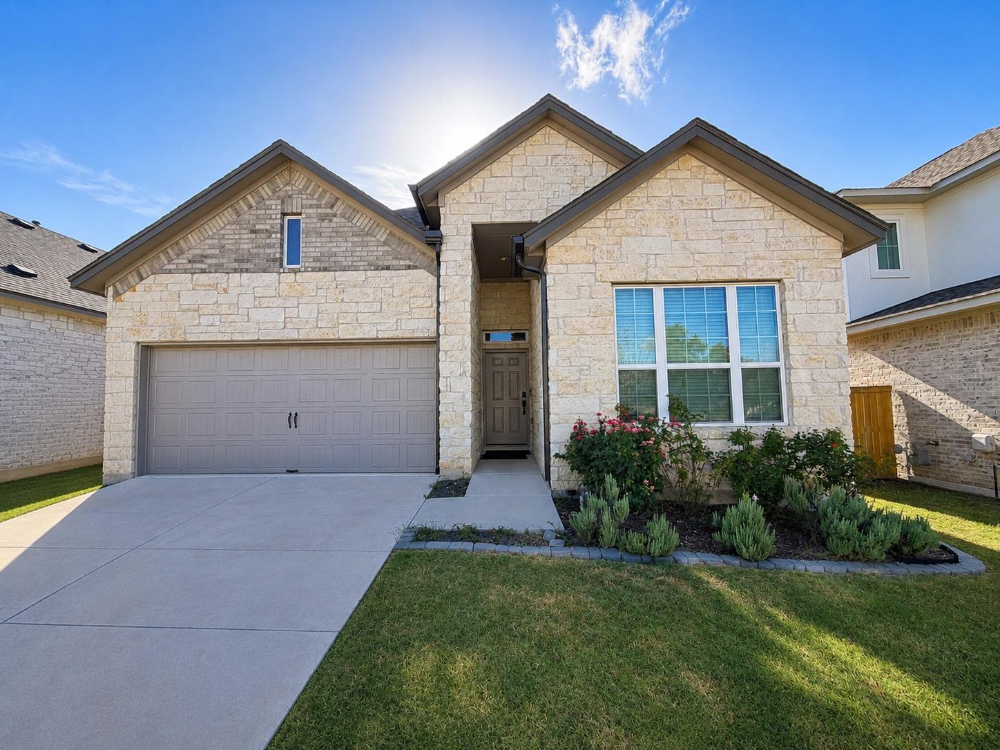 A welcoming stone and brick facade with a two-car