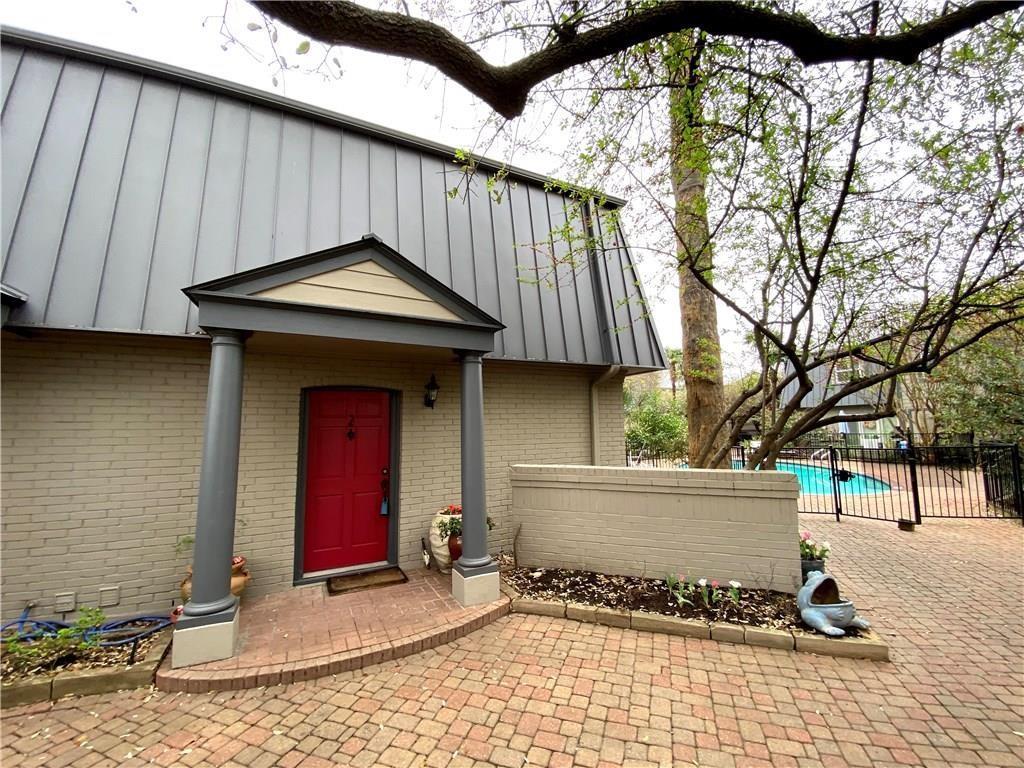 A vibrant red entry door welcomes you to a reside
