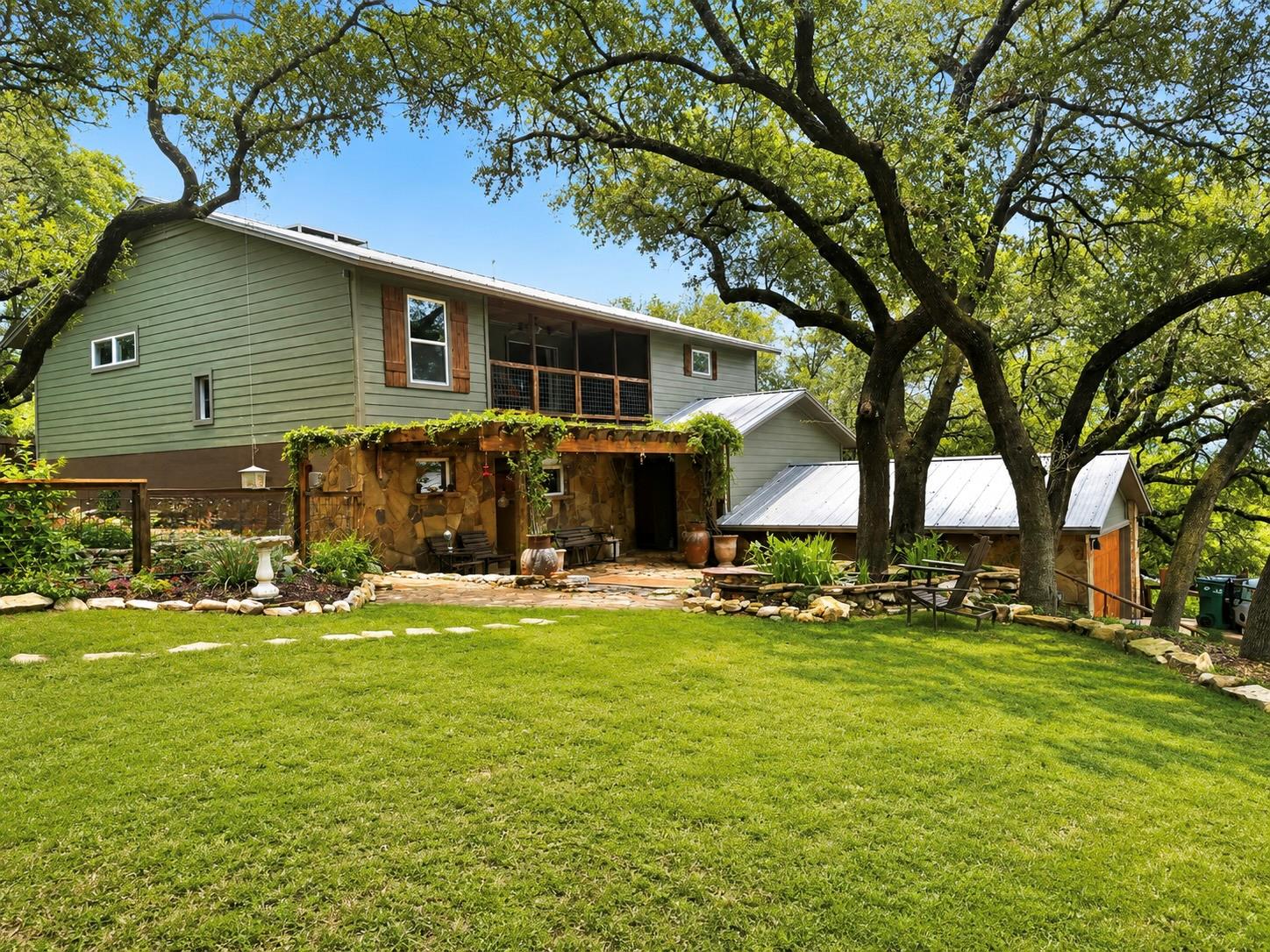 Mature shade trees frame a multi-level home with 