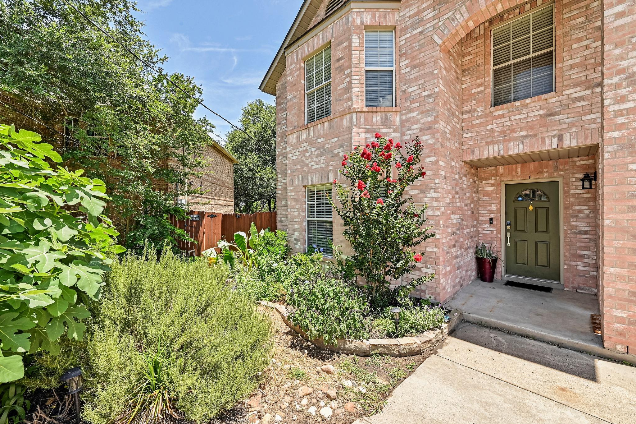 A well-maintained brick facade home with lush lan