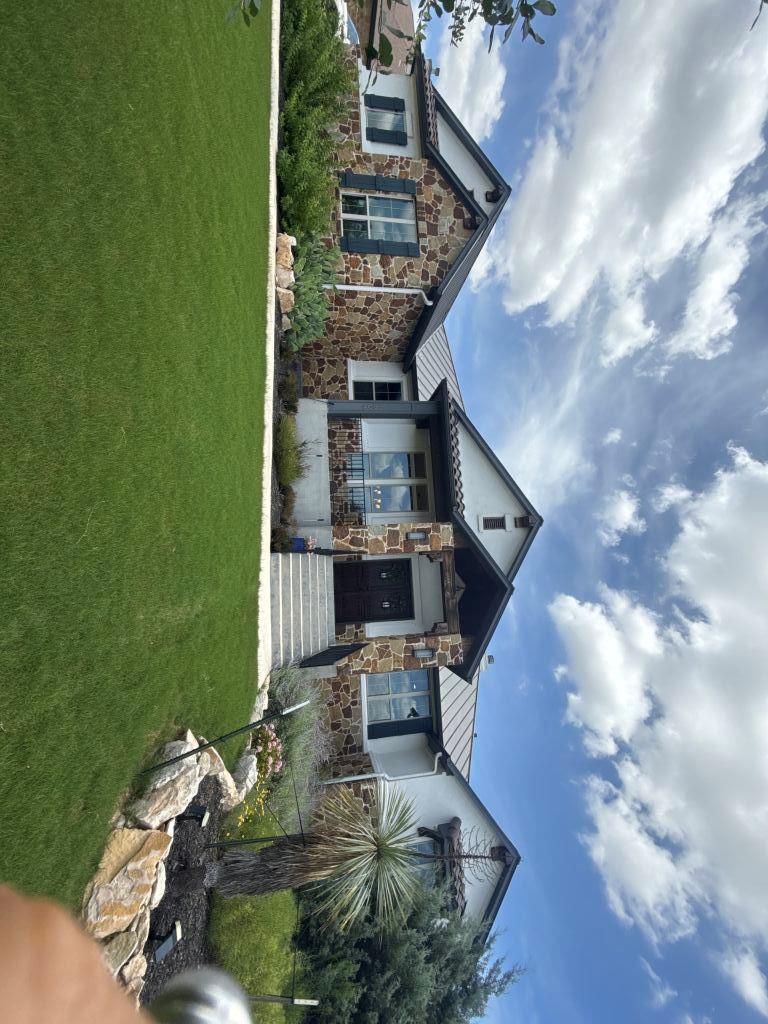 A striking exterior features a beautiful stone fa