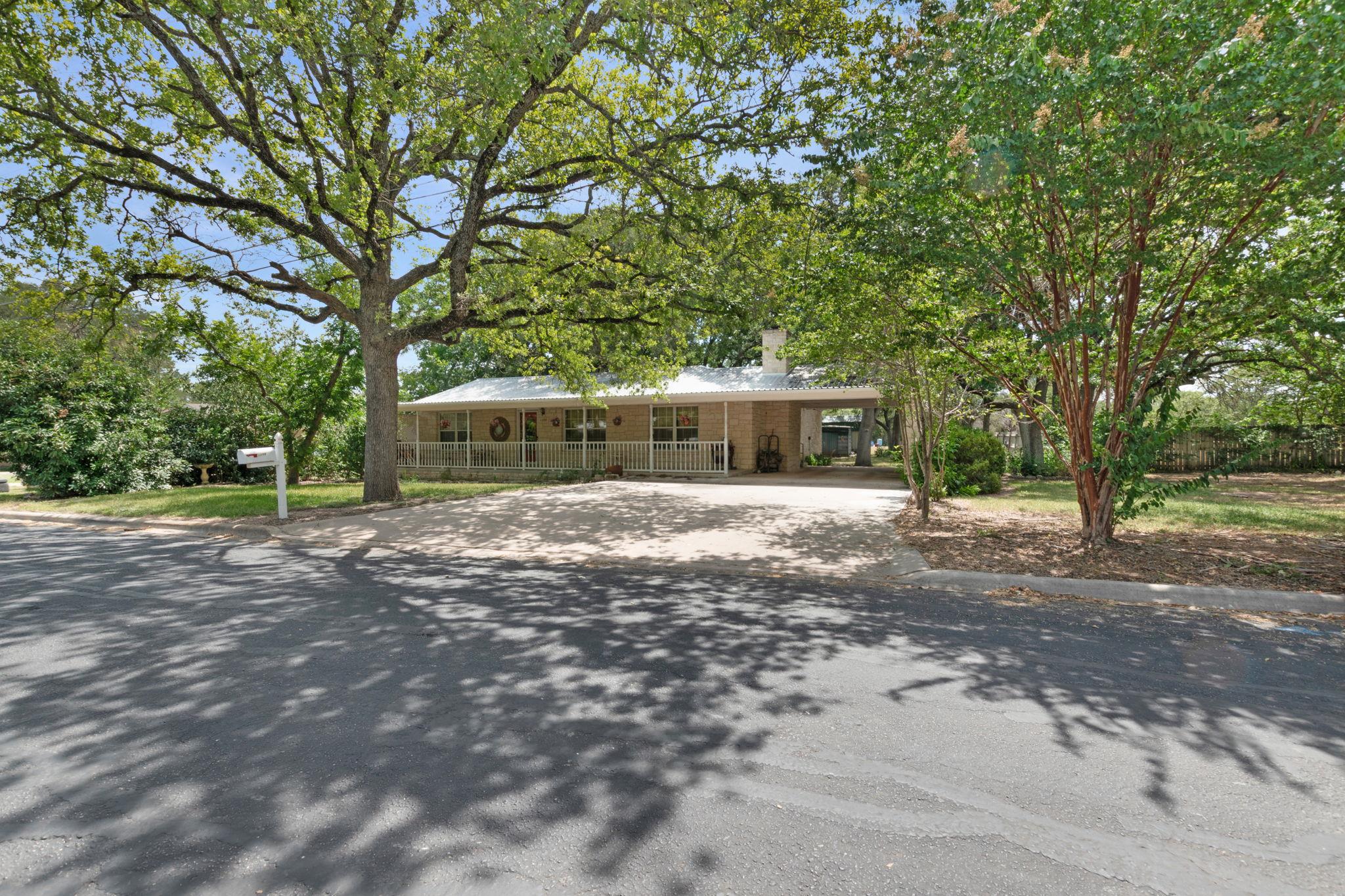 Mature trees shade a charming residence with an i