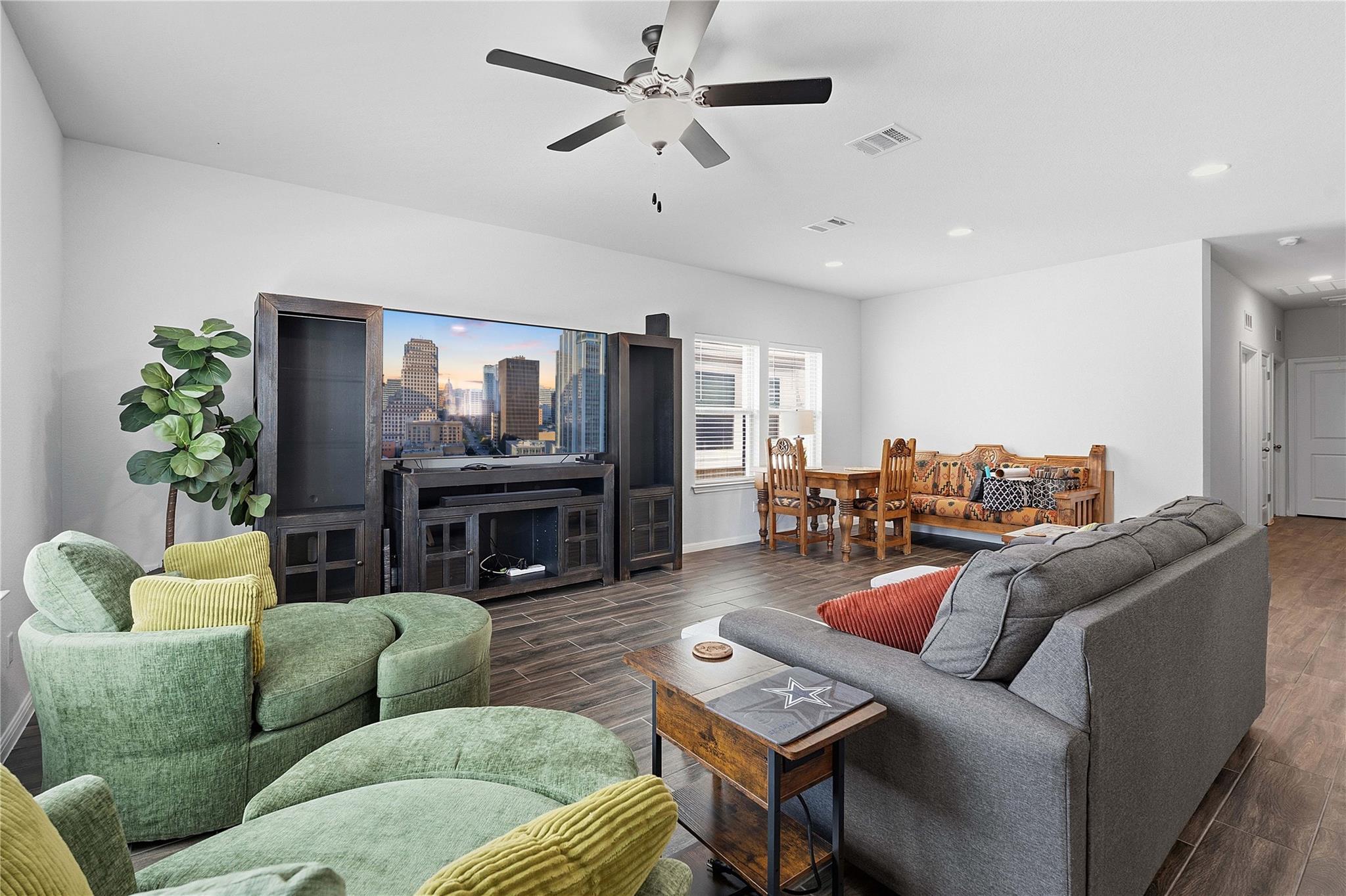 A well-lit living area features dark wood floorin