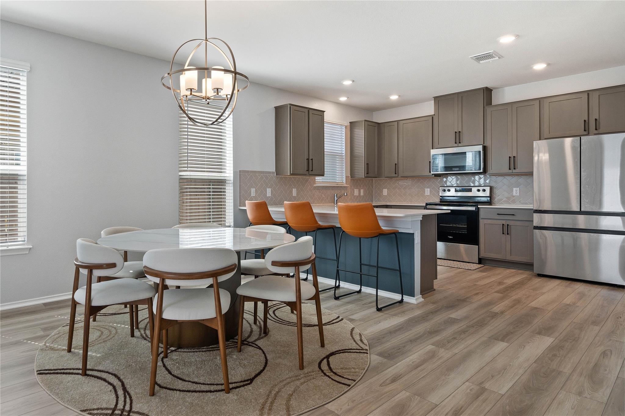 An open kitchen and dining area features modern c
