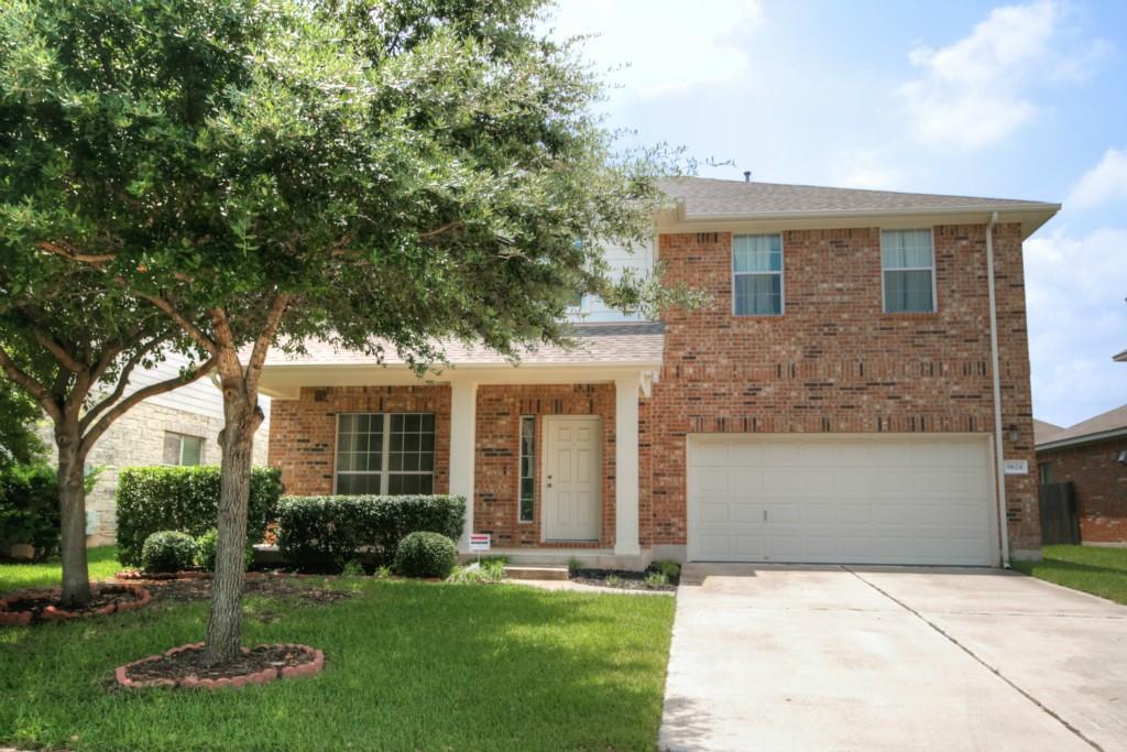 Brick veneer and well-maintained greenery frame a