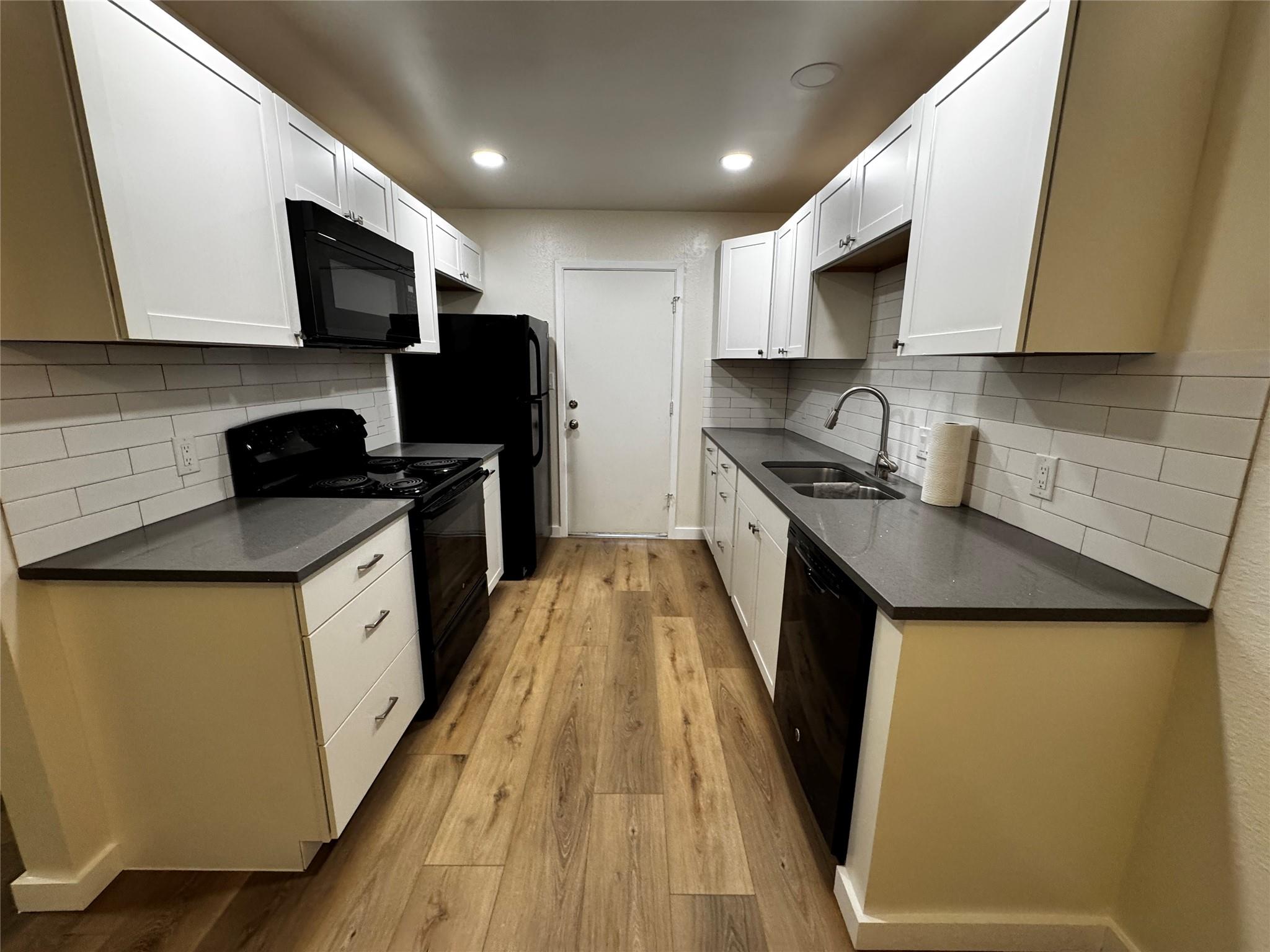 Rich wood-textured flooring complements dark ston