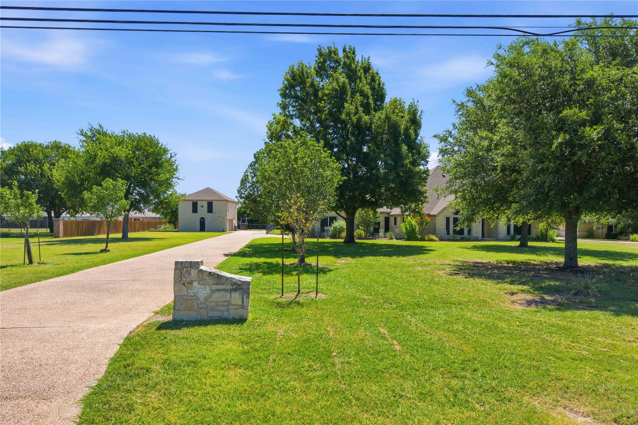 A winding concrete driveway leads to a classic ho