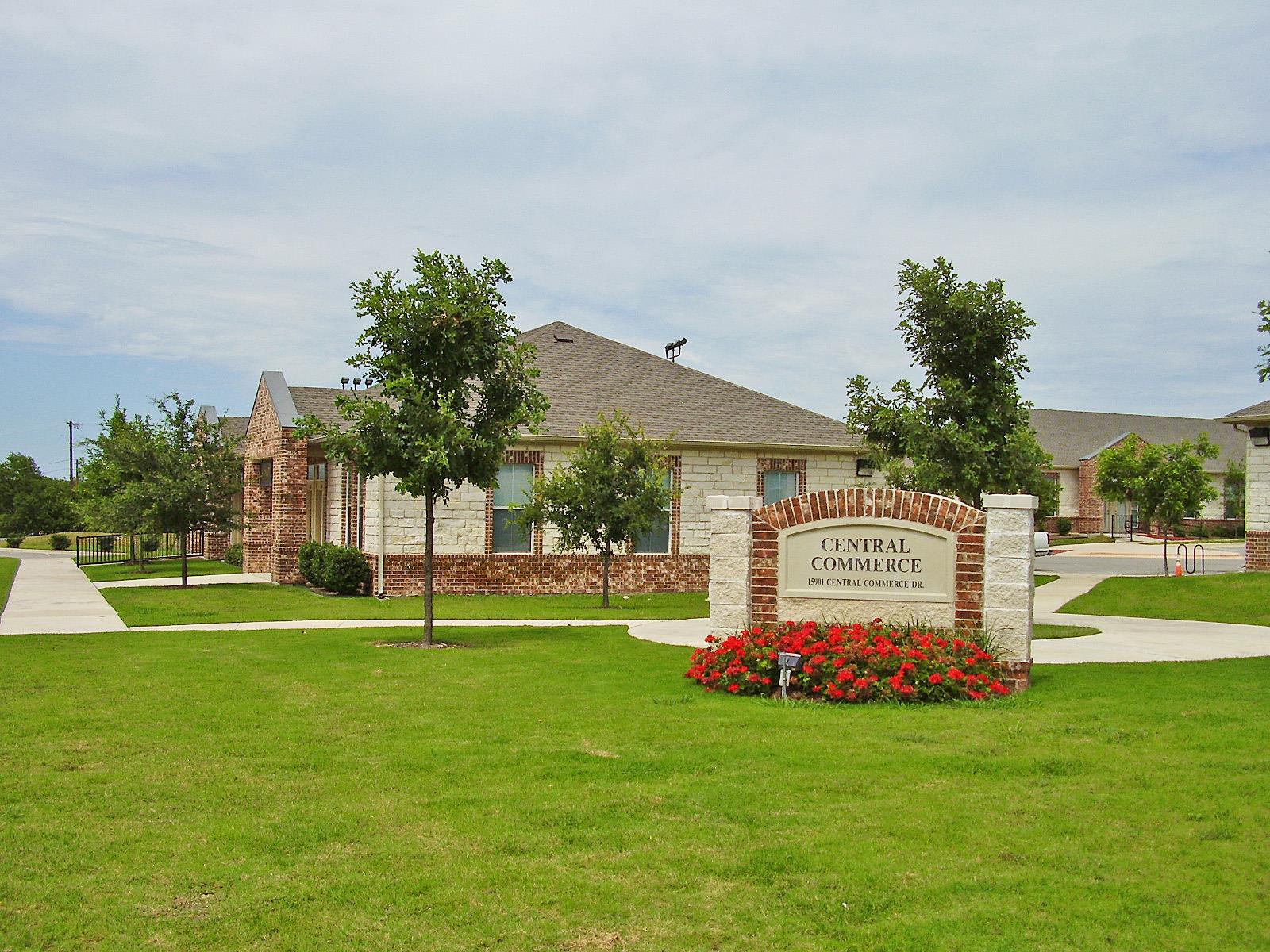 A welcoming stone and brick sign anchors the lush