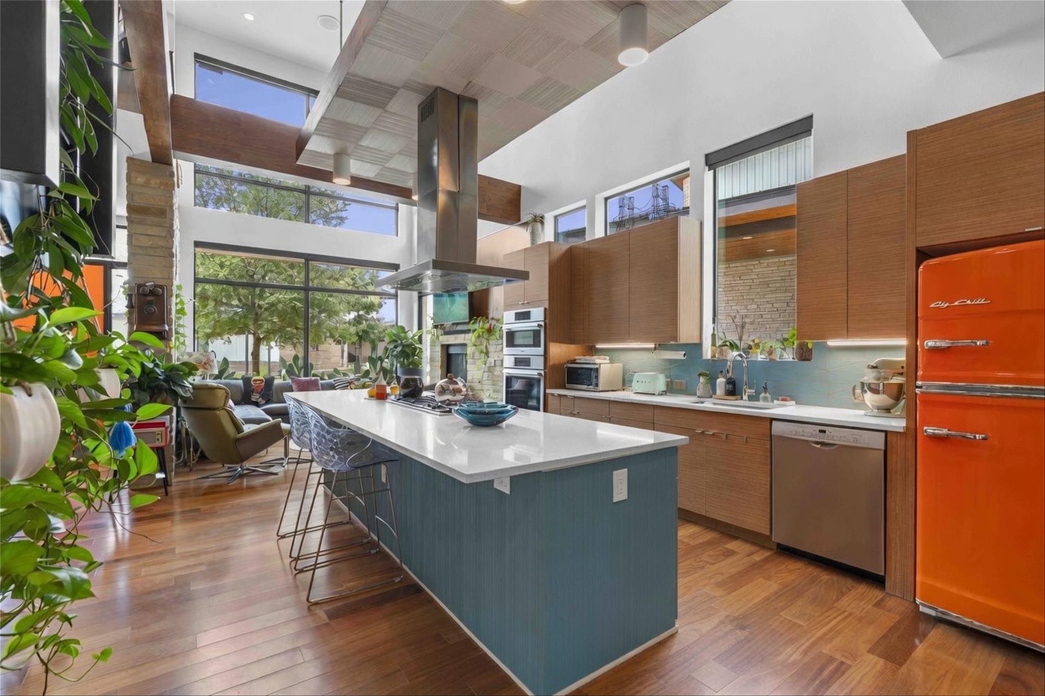 A vibrant kitchen with a teal island and warm woo