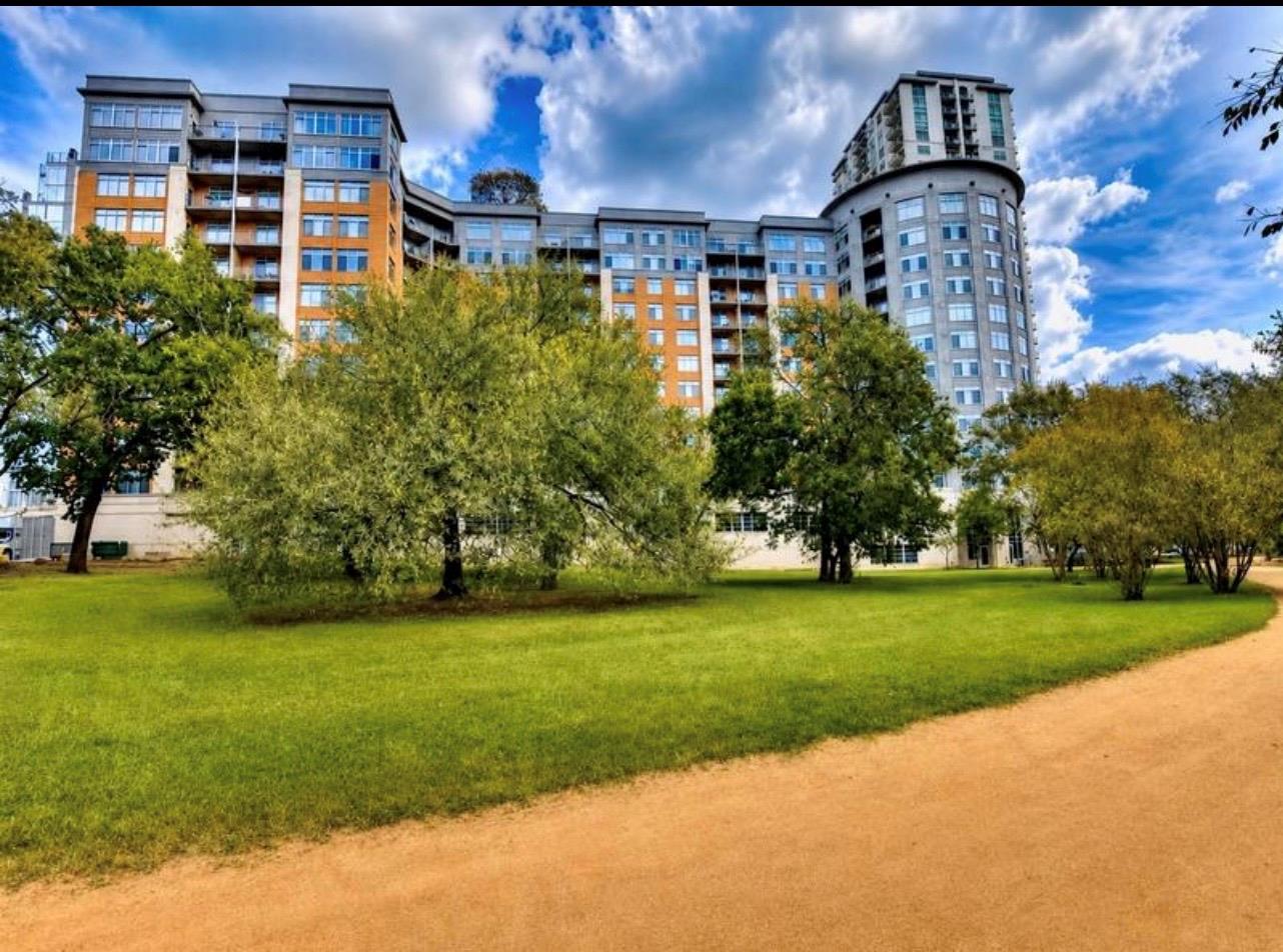 Mature trees and green lawn frame the modern high